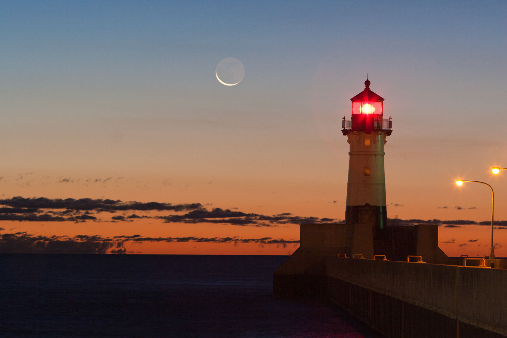 August 21-Crescent Moon SunriseAs dawn breaks in the Northland, a slim crescent moon hangs over Lake Superior.The sight of a slim crescent moon hanging delicately over Lake Superior at dawn in Duluth is breathtaking. The scene's tranquil beauty, with the moon's soft glow reflected on the serene waters of the lake, creates a sense of peace and wonder. He made the moon to mark the seasons; the sun knows its time for setting. Psalm 104:19 This scene is a reminder of God's creation's simple yet profound beauty and a moment to thank God for His wondrous creation.
