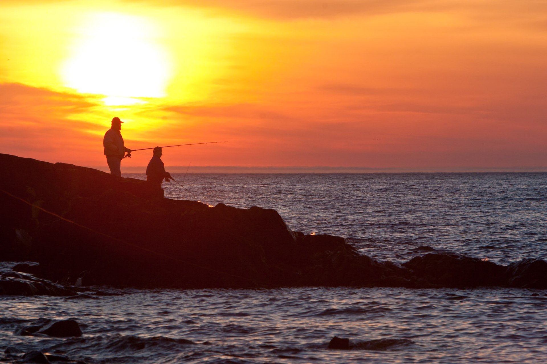 Spingtime on Lake Superior's North Shore brings in salmon and fishermen. This sunrise image at Lester River focuses on a coulbe buddies out in the cool morning air, catching fish, a beautiful sunrise and some good fellowship.