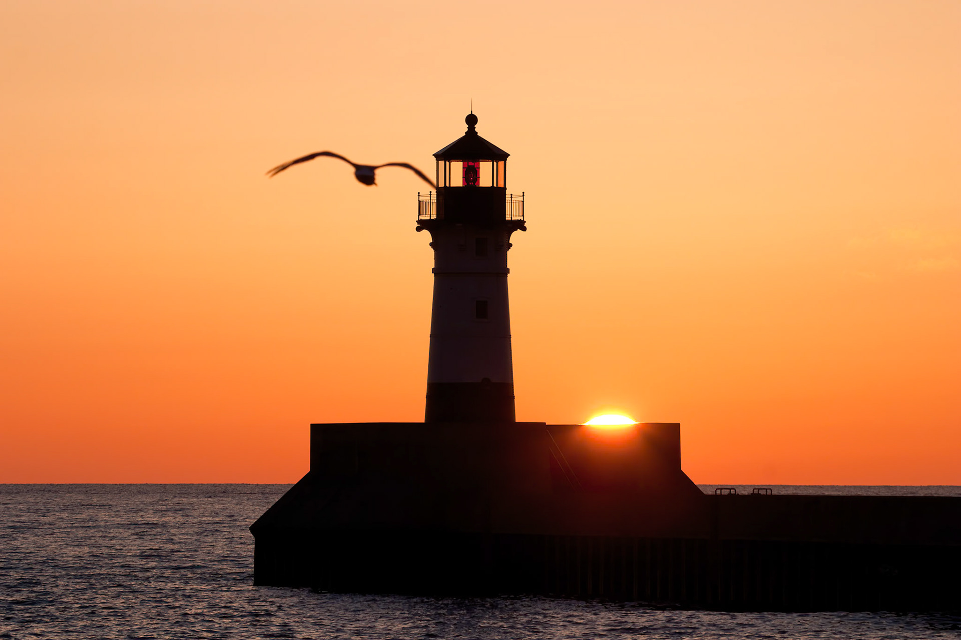 May 17 - Wakeup Time at Canal ParkThe rising sun peeks over the lighthouse seawall for the start of another beautiful day on Lake Superior.God called the light Day, and the darkness he called Night. And there was evening and there was morning, the first day. Genesis 1:5Each day is a gift. Take a minute to thank the Giver!