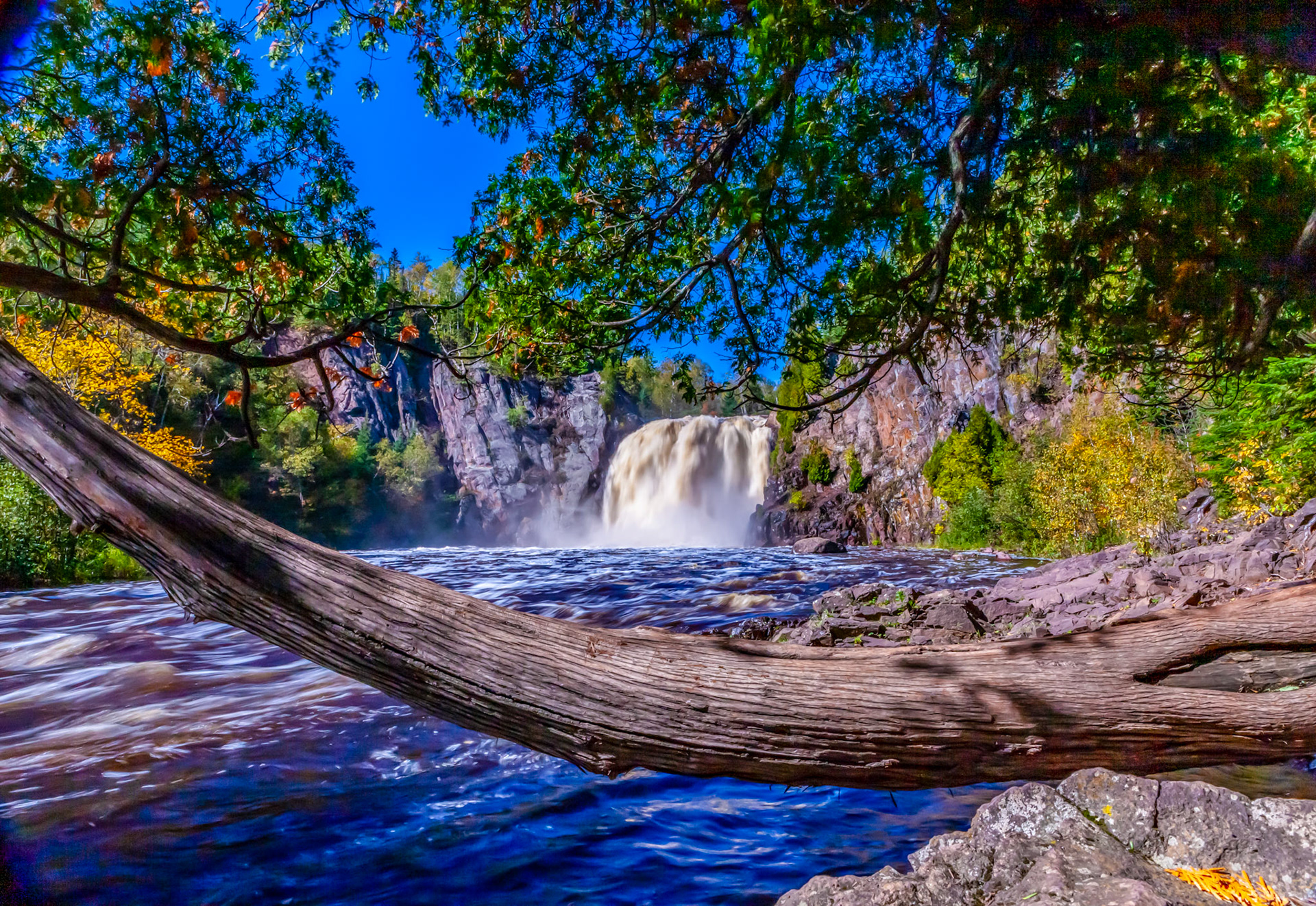 September 22 - Cedar Falls - Temperance River State ParkWith autumn now upon us, the mix of colors and the smell of damp leaves fills our senses with memories of summer days gone by and thankfulness for today.In this scene, the white cedar tree frames the waterfall at Temperance River State Park on the North Shore of Lake Superior.Cedar is a precious wood known for its long life and resistance to rot.This tree grows out of a rocky cliff, and it has the incredible ability to gather nutrients from little earth and hang onto the rock with great strength.God created the simple cedar tree as an example of His perfection and resilience, indicating that the whole earth is full of His Glory.The Strength of GodThe Lord is my strength and my song, and he has become my salvation; this is my God, and I will praise him, my father's God, and I will exalt him.Exodus 15:2