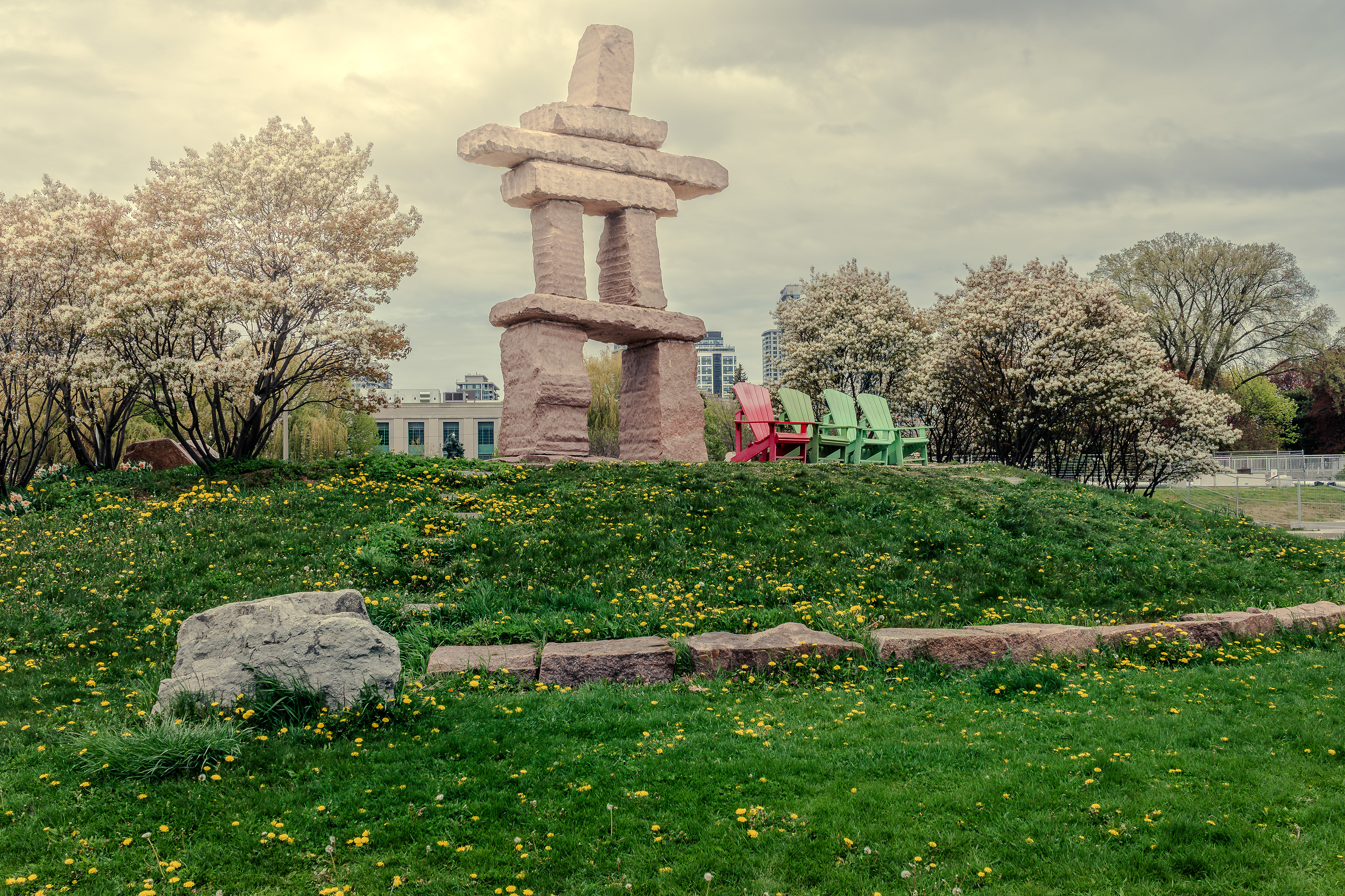Inukshuk monument surrounded by spring blooms at Toronto’s waterfront park.