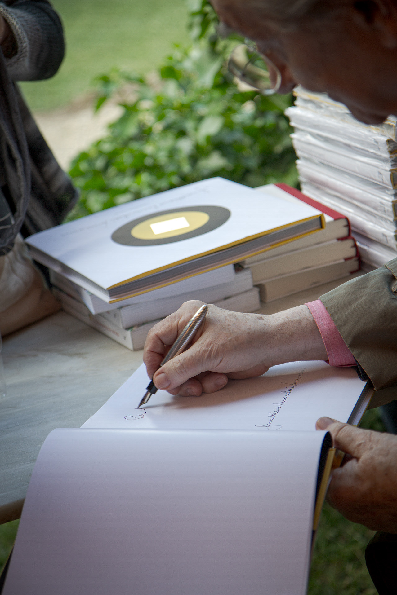 Legacy and Signature: The intimate ritual of the book signing. Capturing the personal connection between the Maestro and his audience at an exclusive cultural event.