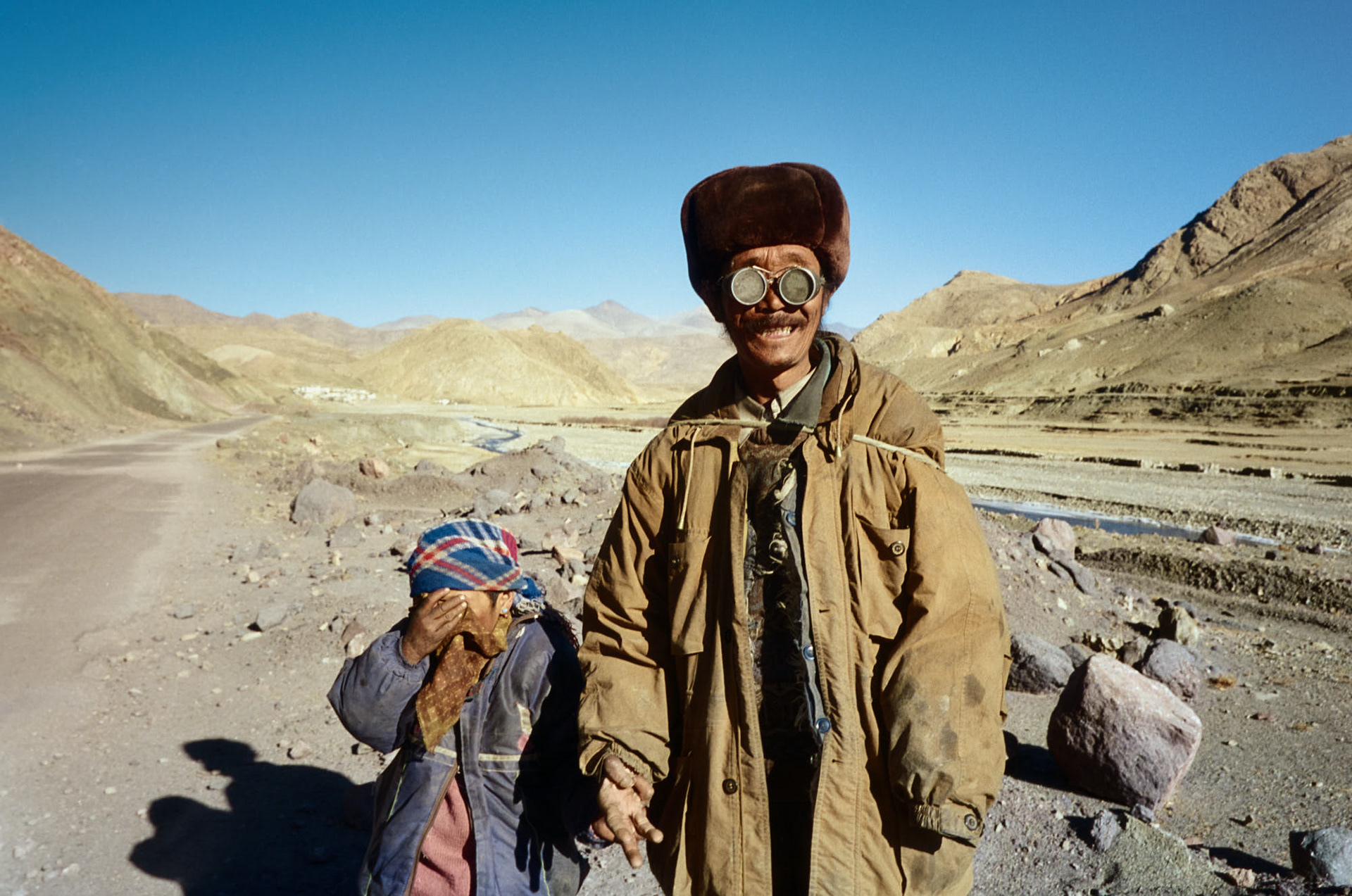 Tibet near Lhasa - Blind man on his way, led by a young girl.