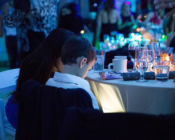 small boy reading at table by candlelight
