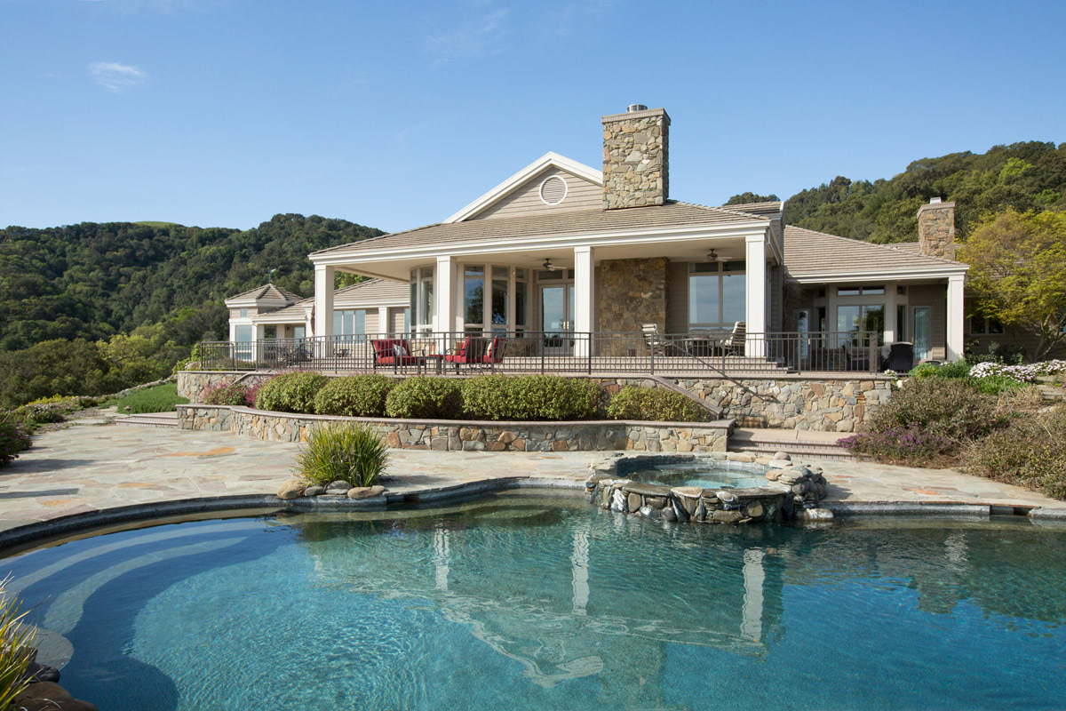 rear-ofhome-with-covered-balcony-and-pool-with-spa