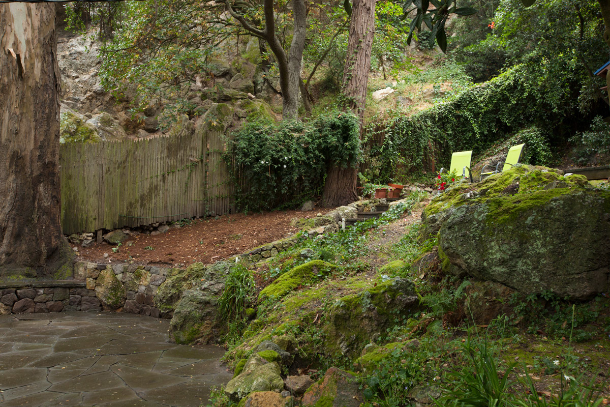 two-green-chairs-perched-above-a-stone-patio-in-a-rustic-setting