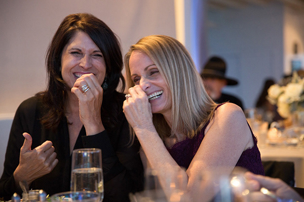 two women laughing at the table