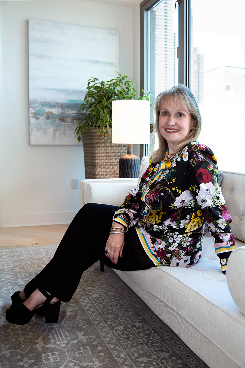 woman-wears-a-floral-top-seated-by-window