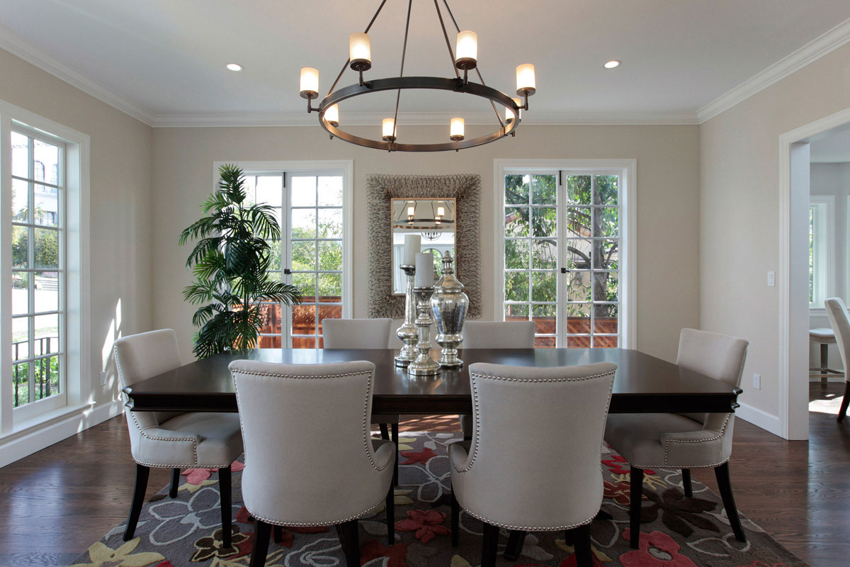 dining-room-with-garden-views-six-grey-velvet-chairs-around-a-black-rectangular-table-with-round-wrought-iron-chandelier