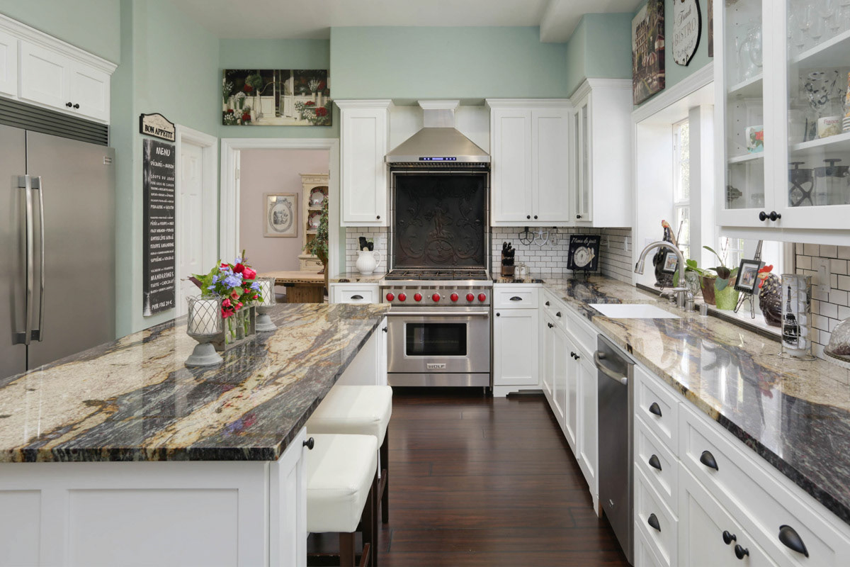 kitchen-with-white-cabinets-mint-green-walls-ceter-island-grey-granite-counters-stainless-steel-appliances-darkwood-floors