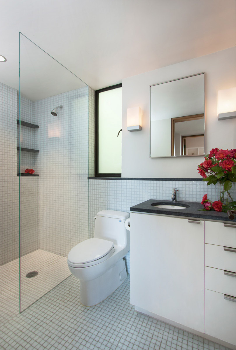 tile-white-bathroom-with-stall-shower-and-red-roses-on-a-black-counter-top-vanity