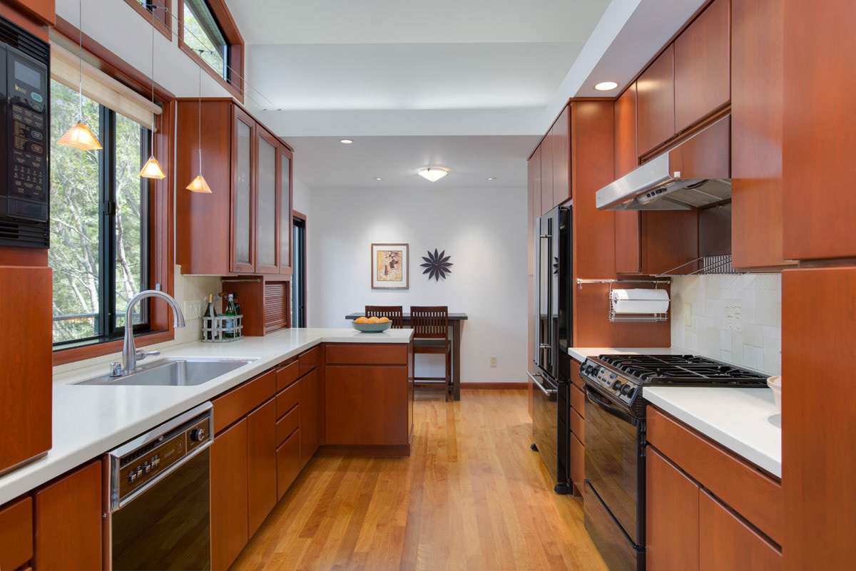 galley-kitchen-cherry-stained-cabinets-white-quartz-counters