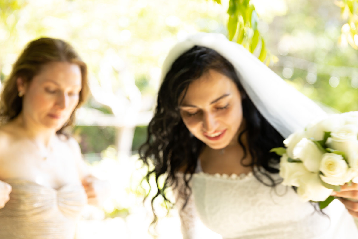 bride-and-maid-of-honor-walk-carefully-down-a-path