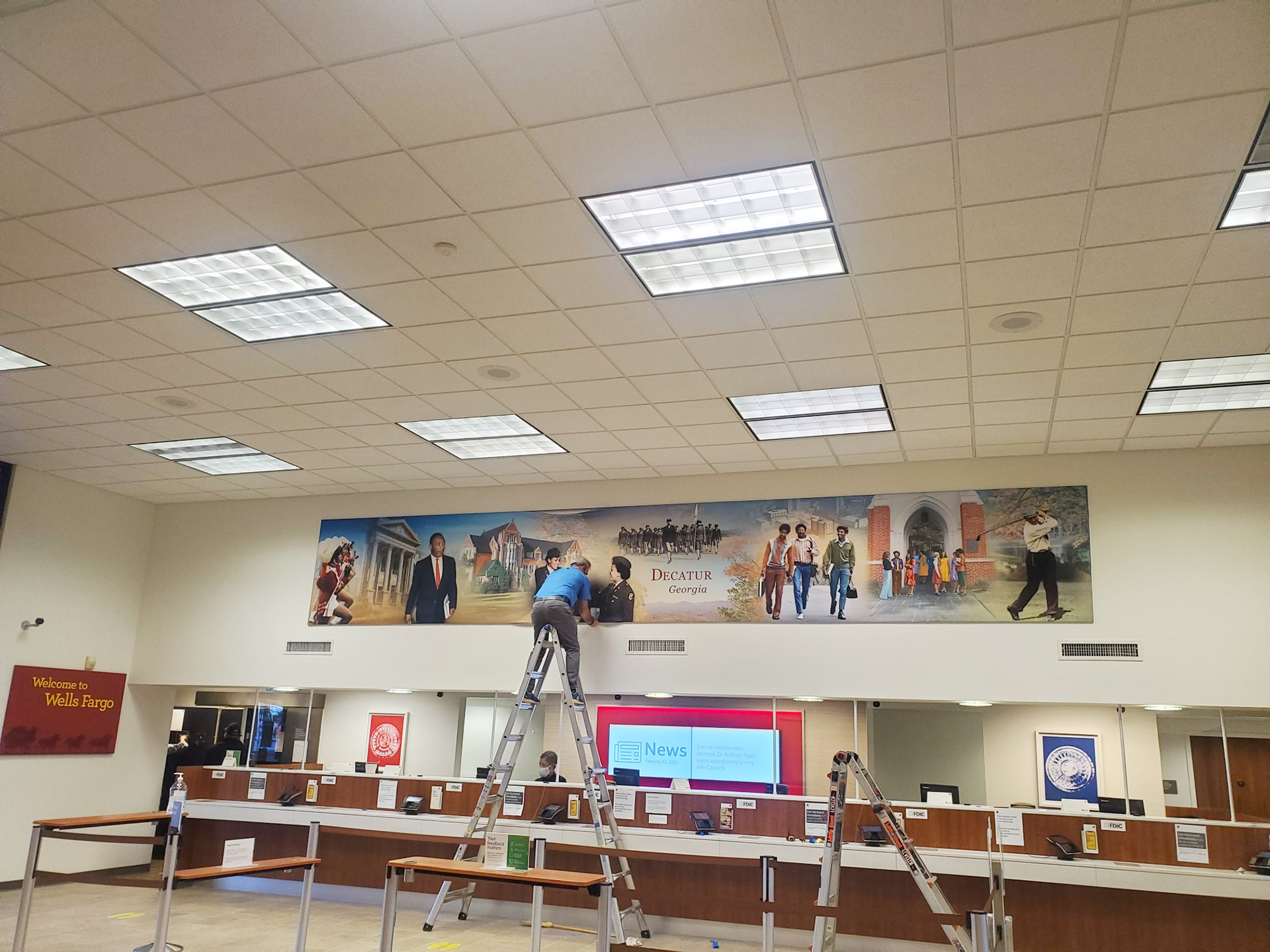 Installing the panoramic mural in the branch lobby.