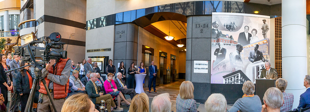 Audience and media gathered beside the Eccles and First Security Heritage Mural during its unveiling in the Wells Fargo Center lobby.