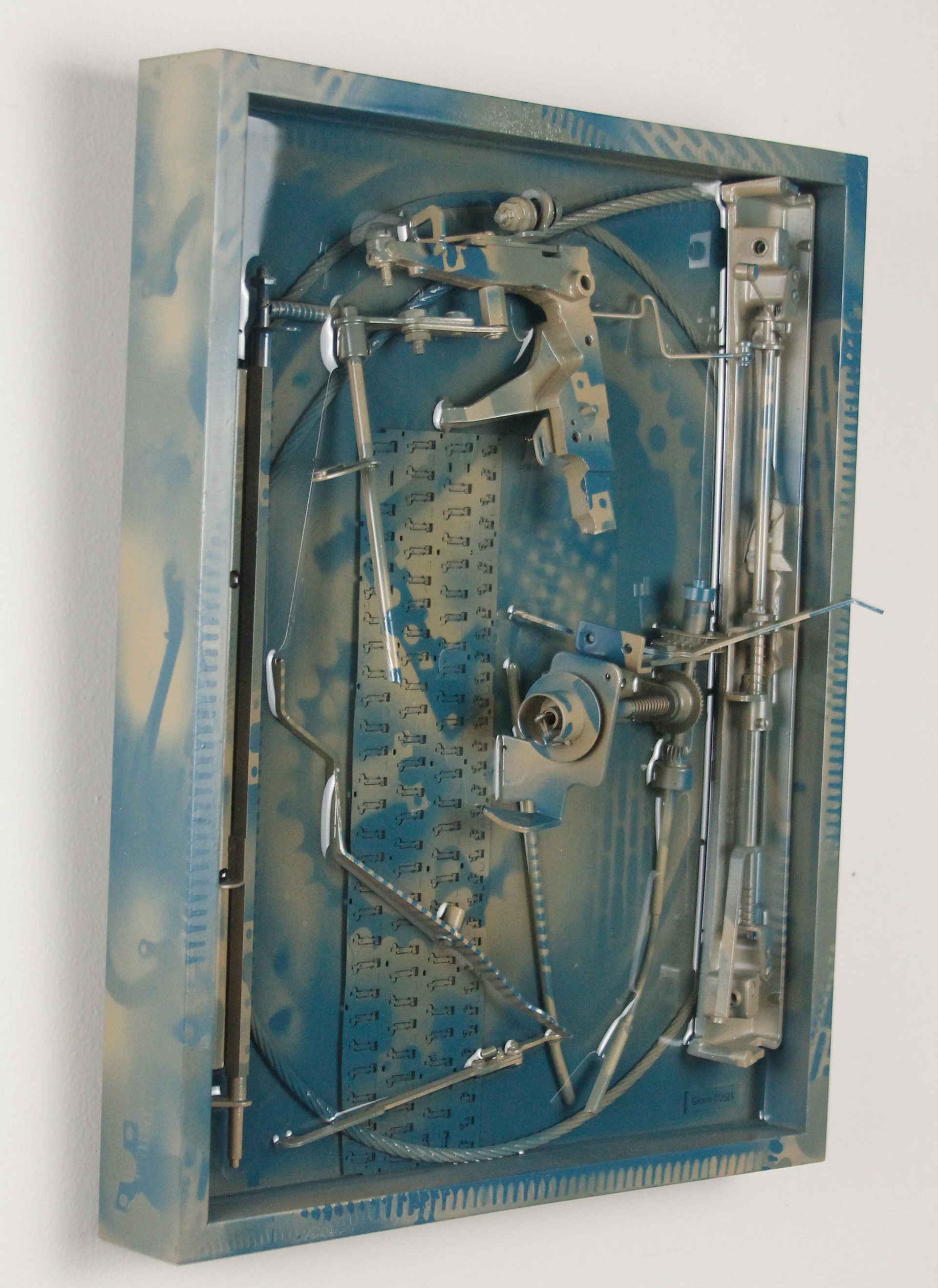 Concinnity; $1300 (H:16.375” x W:12.3125” x D:3.25”) Steel cable, underside of partial laptop keyboard, typewriter parts, spray paint, epoxy resin, wood backing