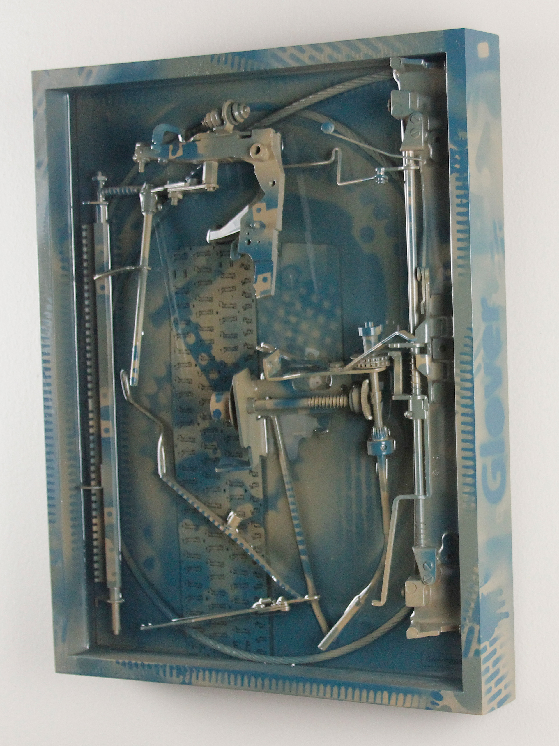 Concinnity; $1300 (H:16.375” x W:12.3125” x D:3.25”) Steel cable, underside of partial laptop keyboard, typewriter parts, spray paint, epoxy resin, wood backing