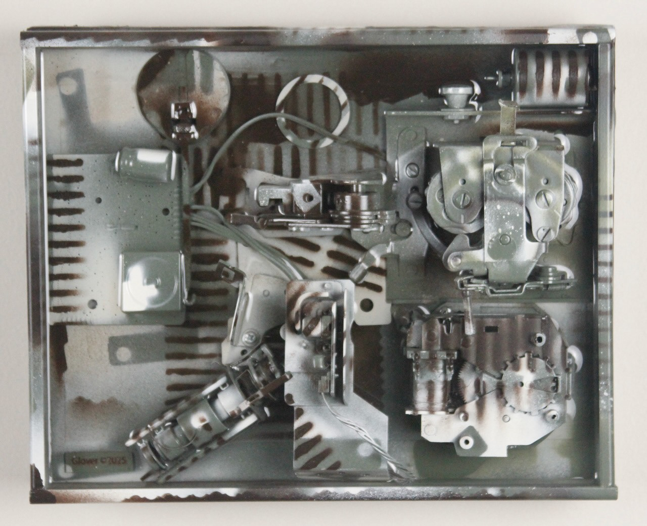 Kit; $520 (H:8” x W:10” x D:3.5”) Assorted machine parts, spray paint, epoxy resin, canvas covered wood base