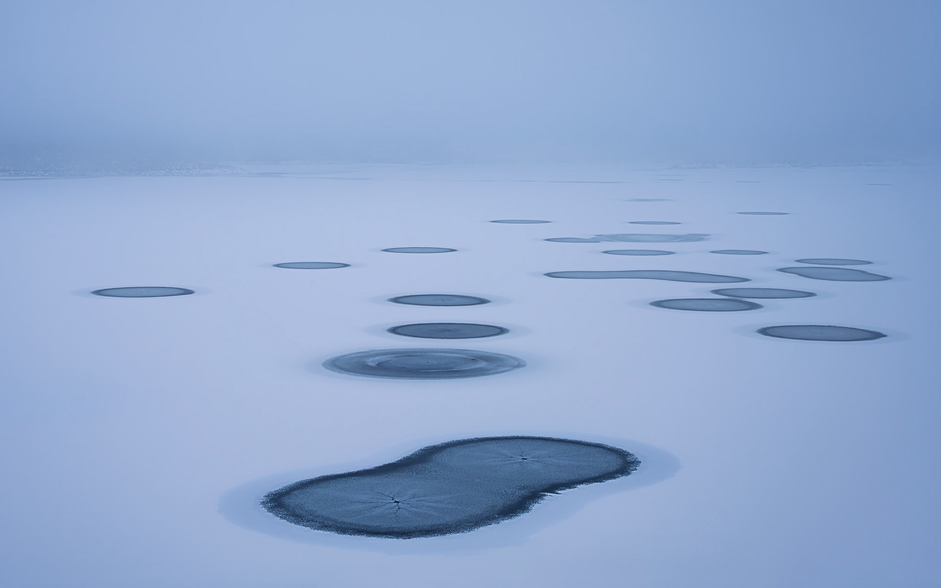Winter casts a soft blue veil over the lake's alien surface.