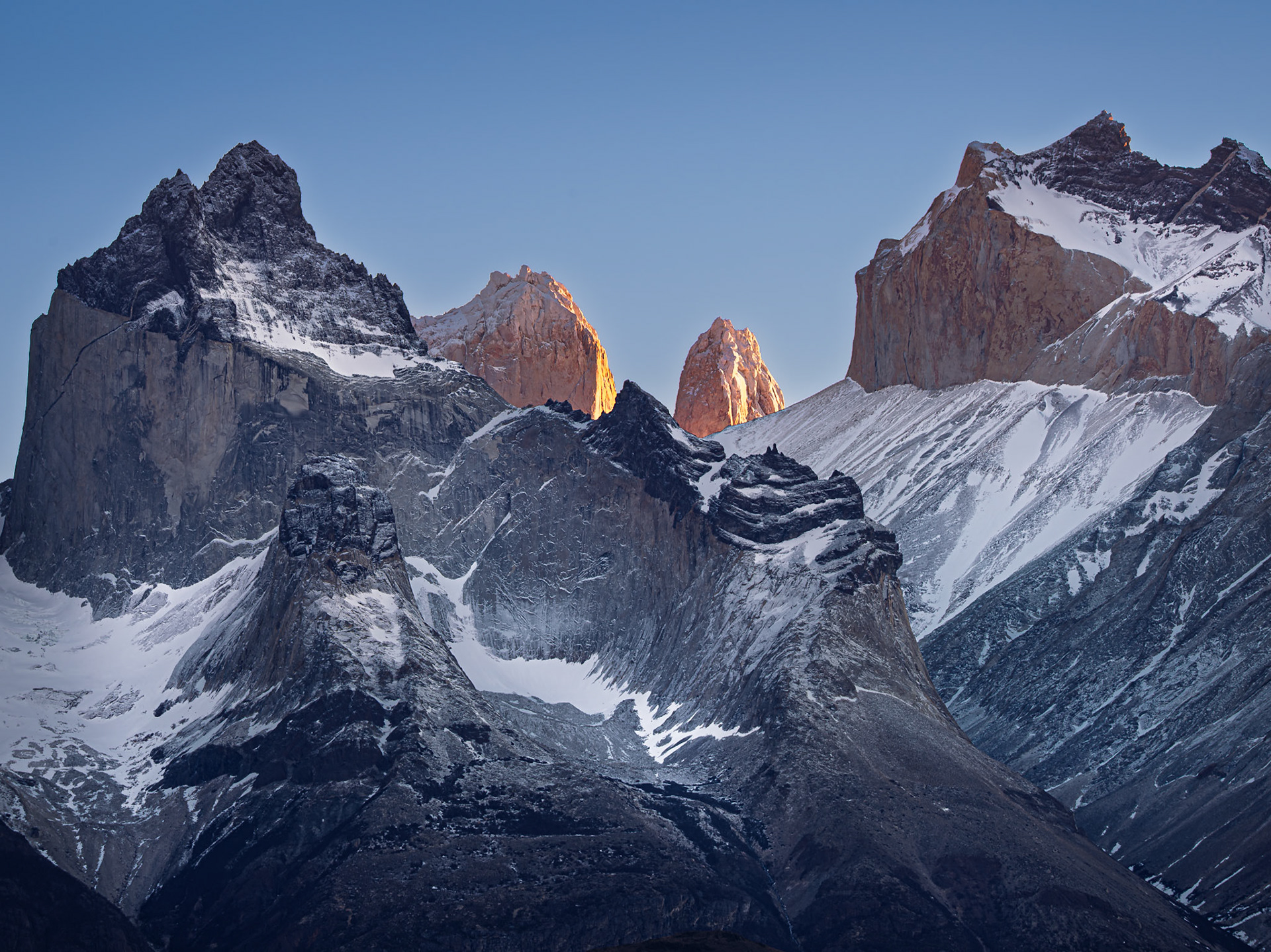 Torres del Paine's jagged peaks illuminated at daybreak.