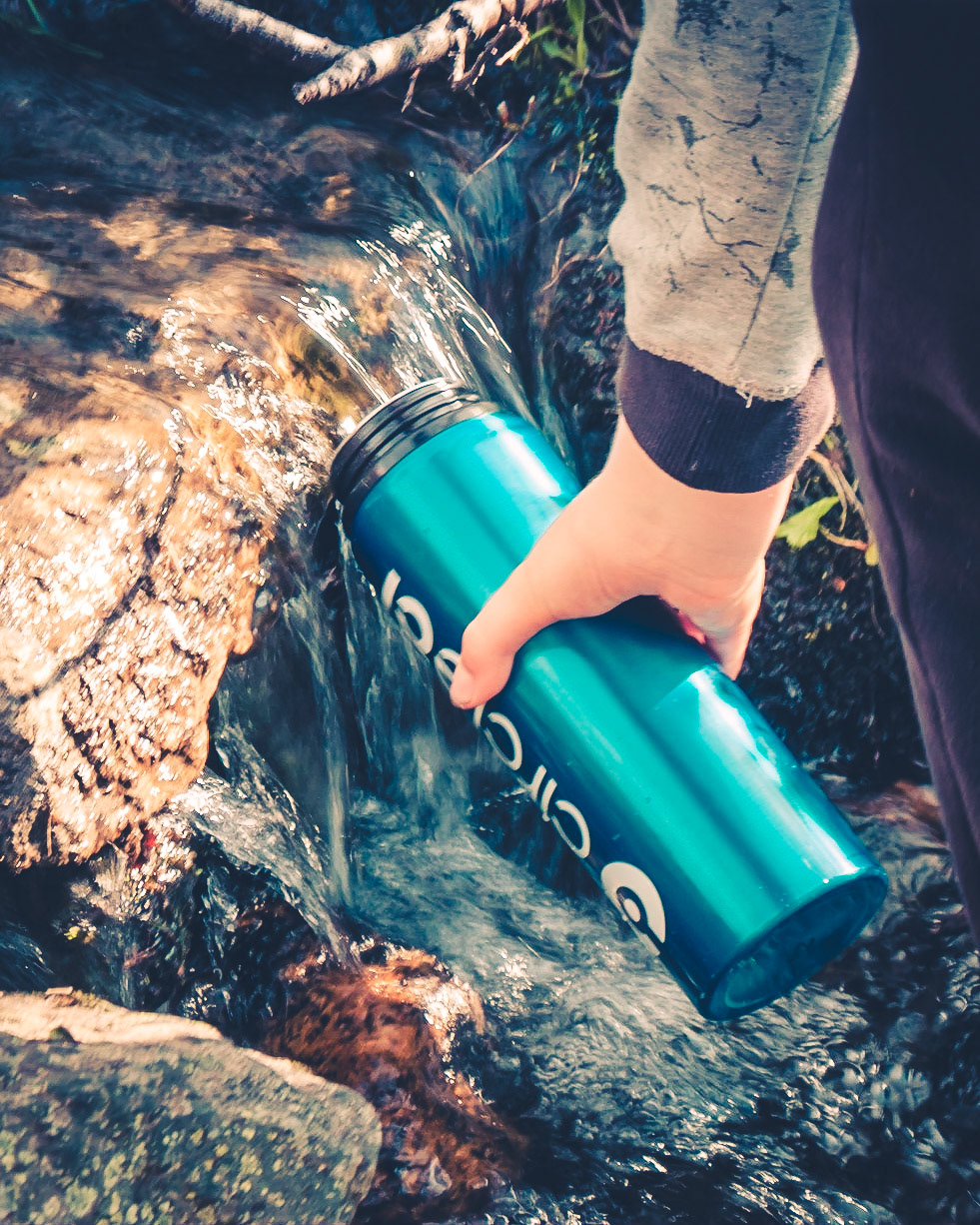 Filling the water bottle from a mountain stream