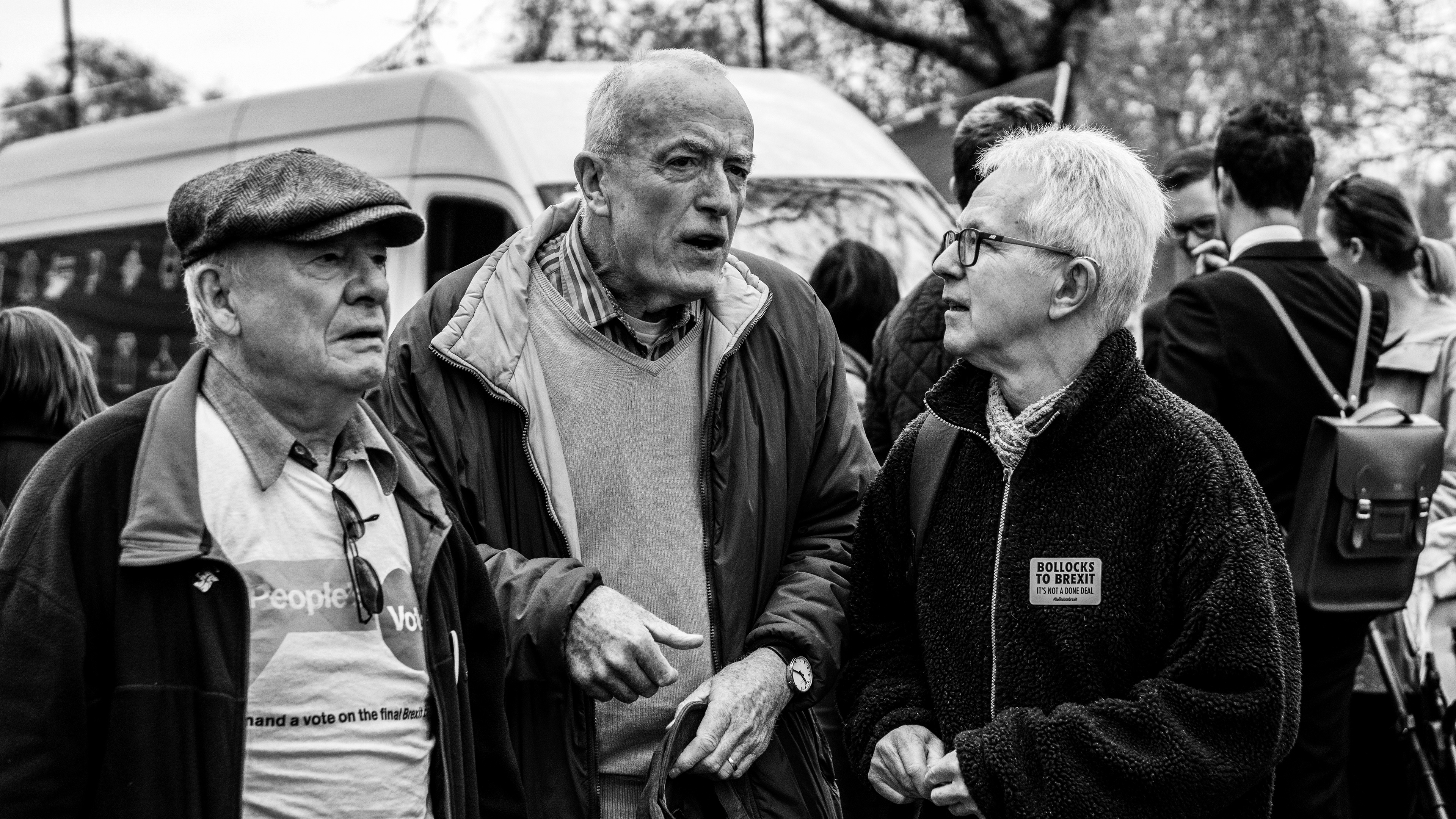Black and white photography. 3 English man a discussing the future of England. The image was captured in London during the 2019 Brexit March
