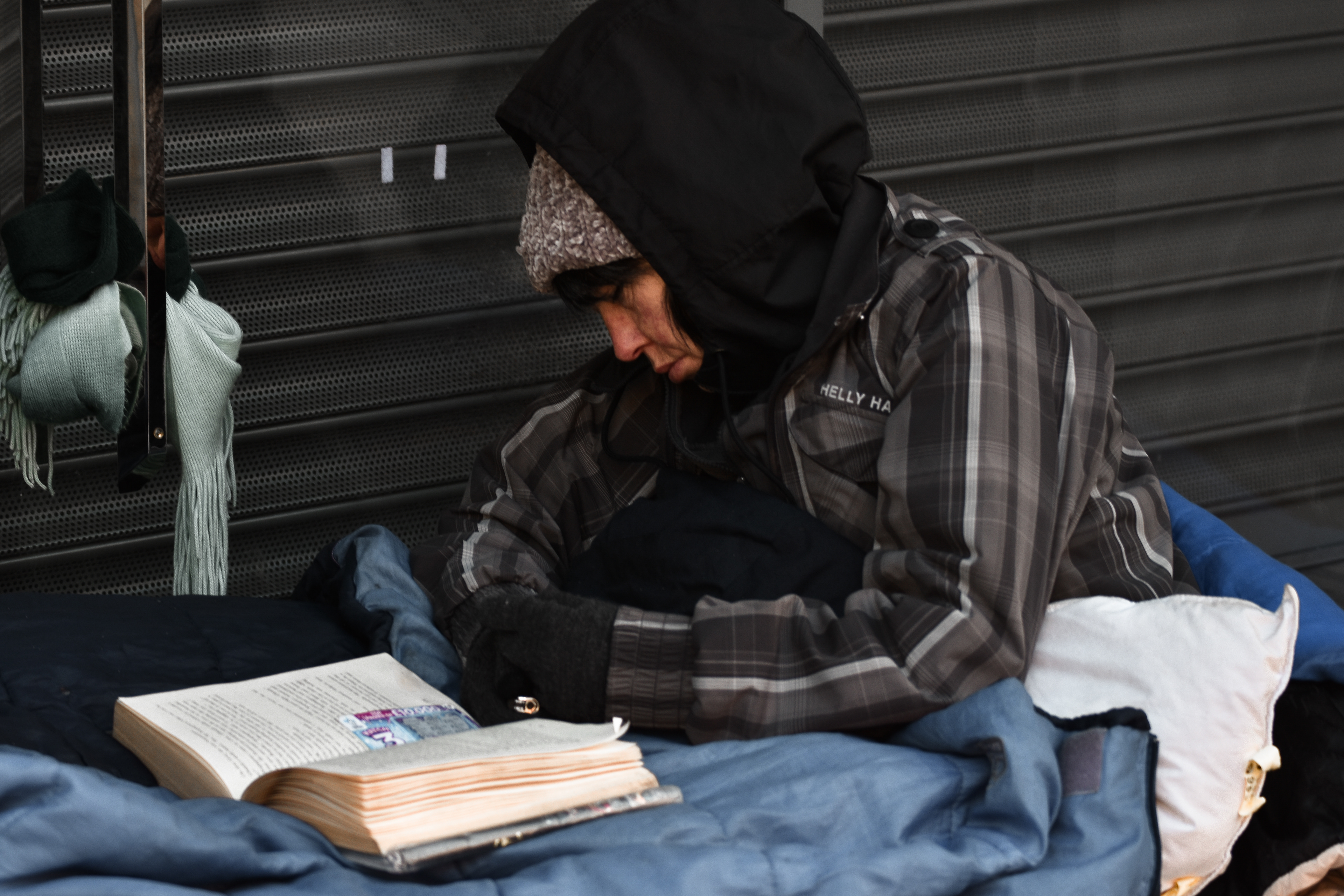 Street photograph taken in West Midlands, Worcester. It was cold winter day, I had my Nikon camera with me when I saw this woman sleeping on the street with her book in front of her. Captured emotion.