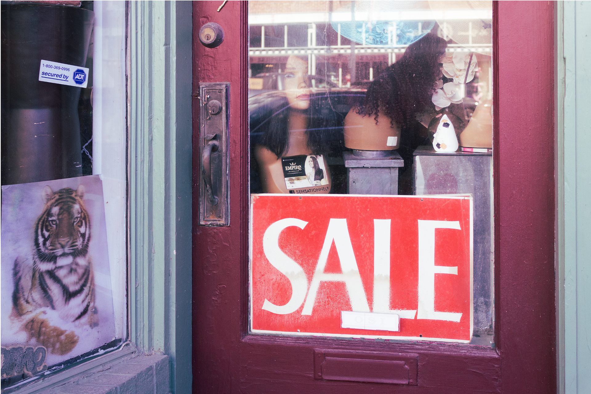 The sale sign and peculiar items invite shoppers into the store.