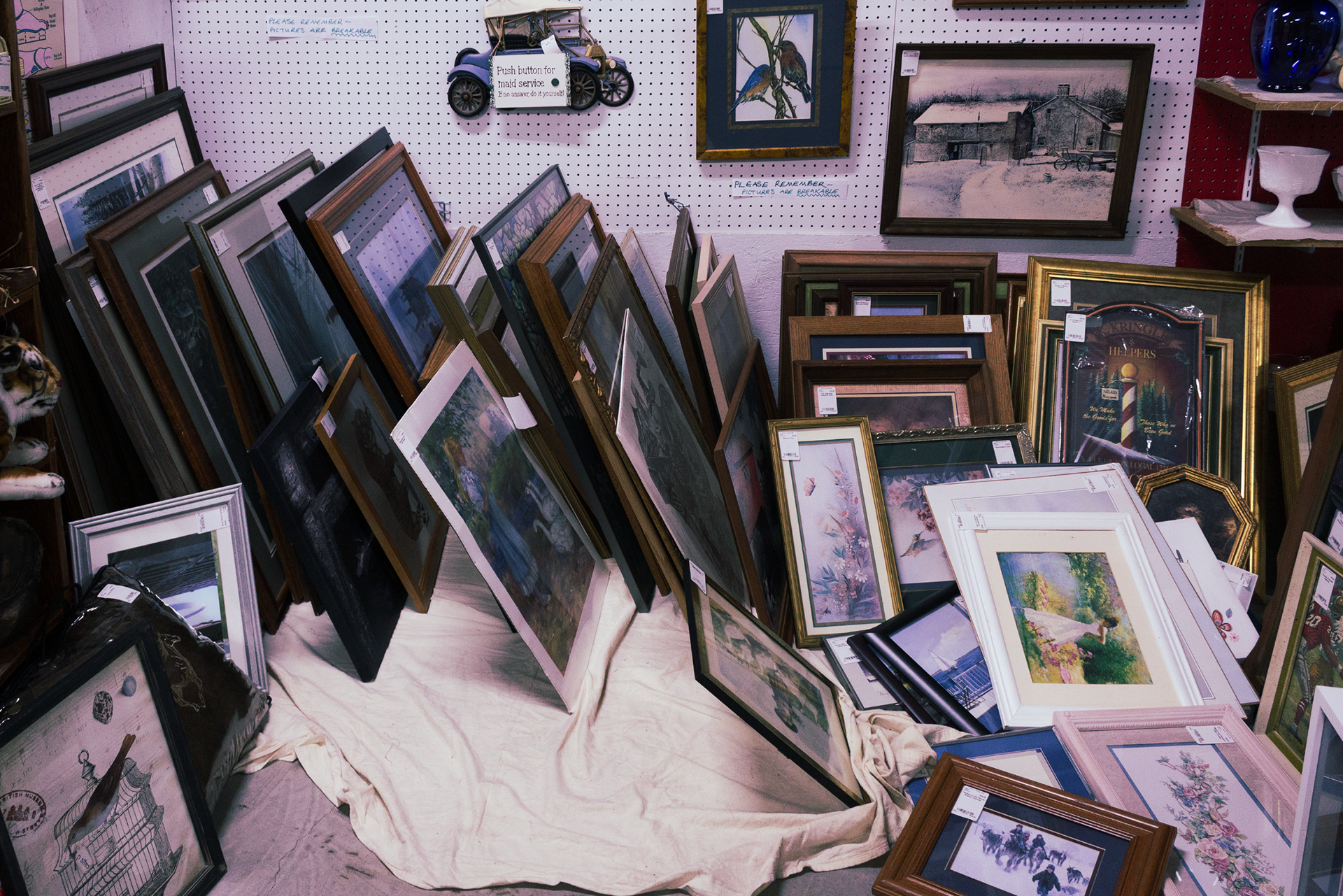 Dozens of picture frames are clumsily lined up in a booth.