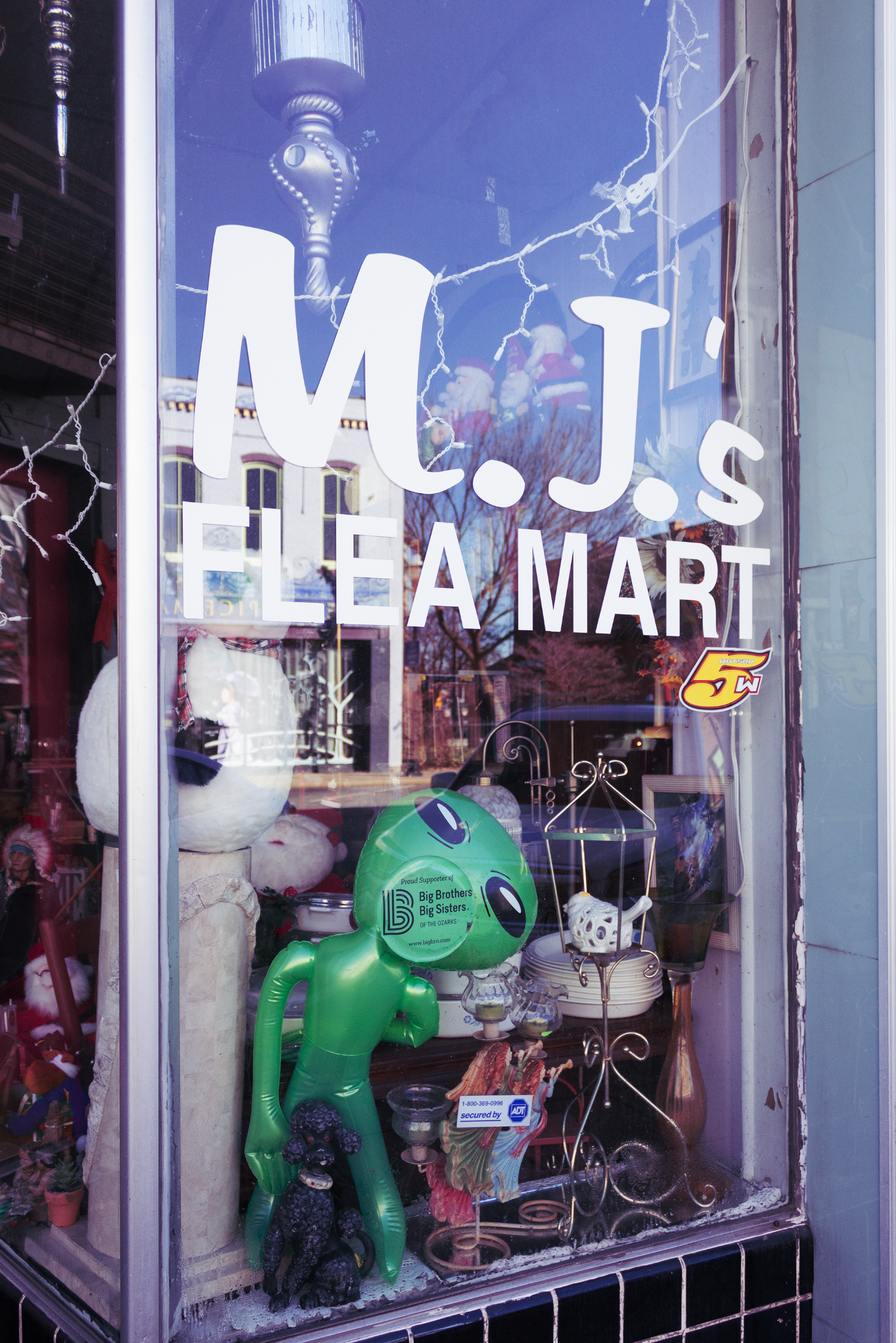 The windows of a flea market show the amount of items within its walls.