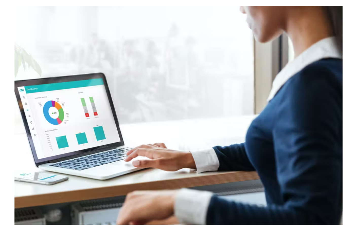 Business woman sitting with laptop looking at charts.