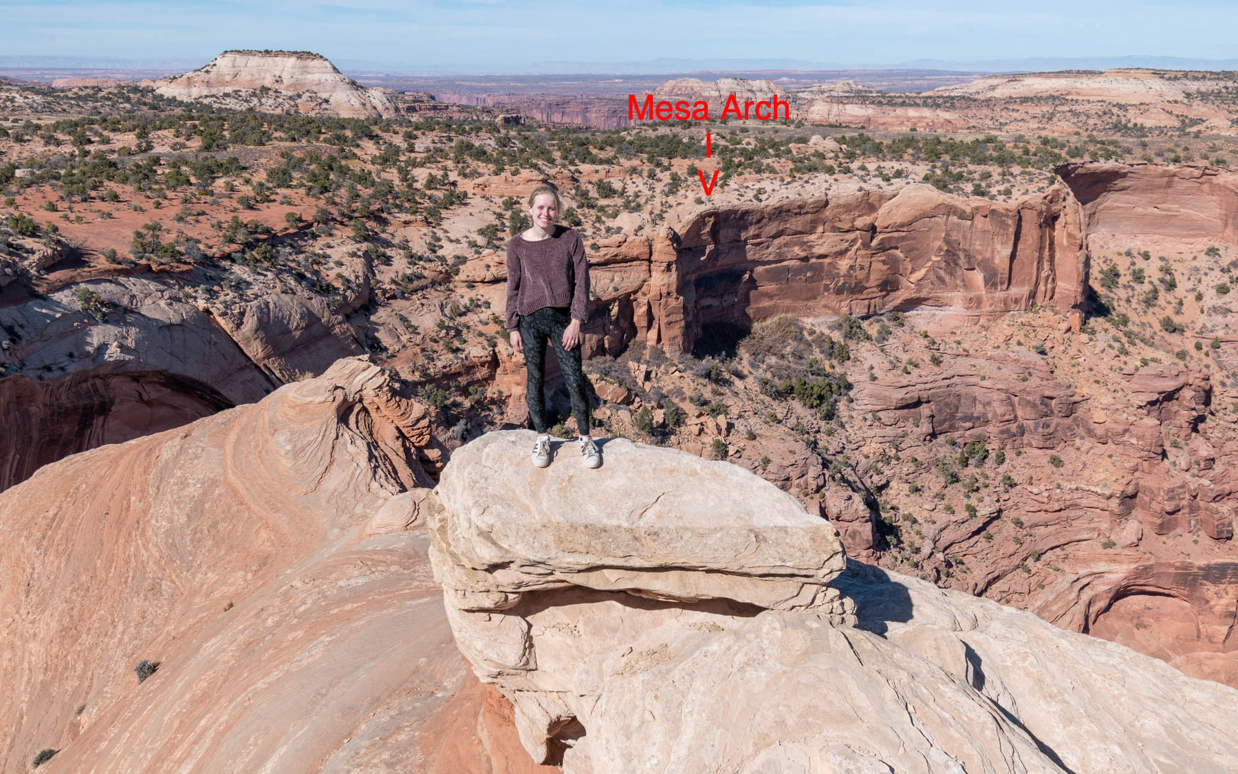 Mesa Arch is to the right of Grace's head