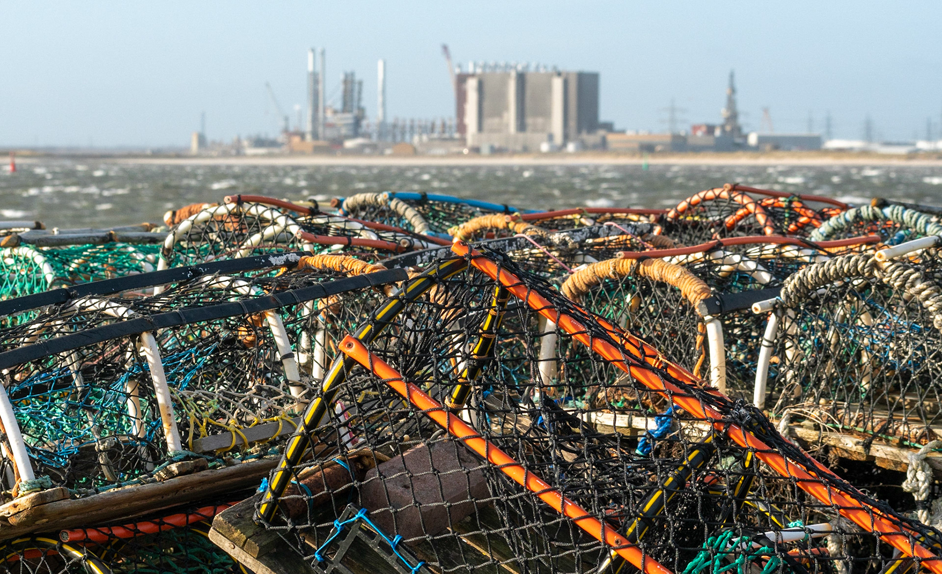 Lobster pots at Paddy's Hole, Hartlepool nuclear power station across Teesmouth.