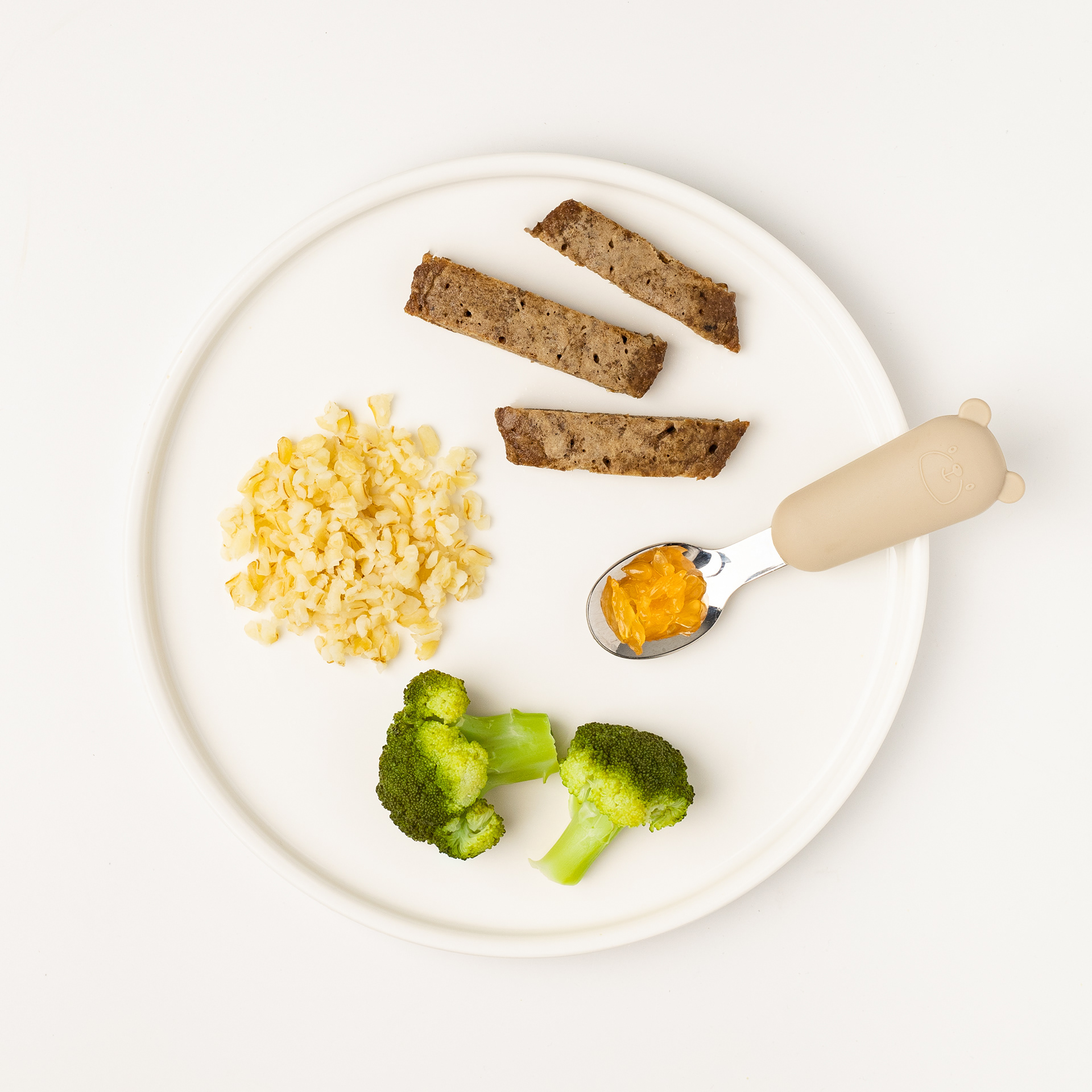 Тарілка з дитячою їжею: булгур, броколі, смужки м’яса та ложка з пюре. Фуд-фото Уляни Копаниці для додатку з дитячого харчування