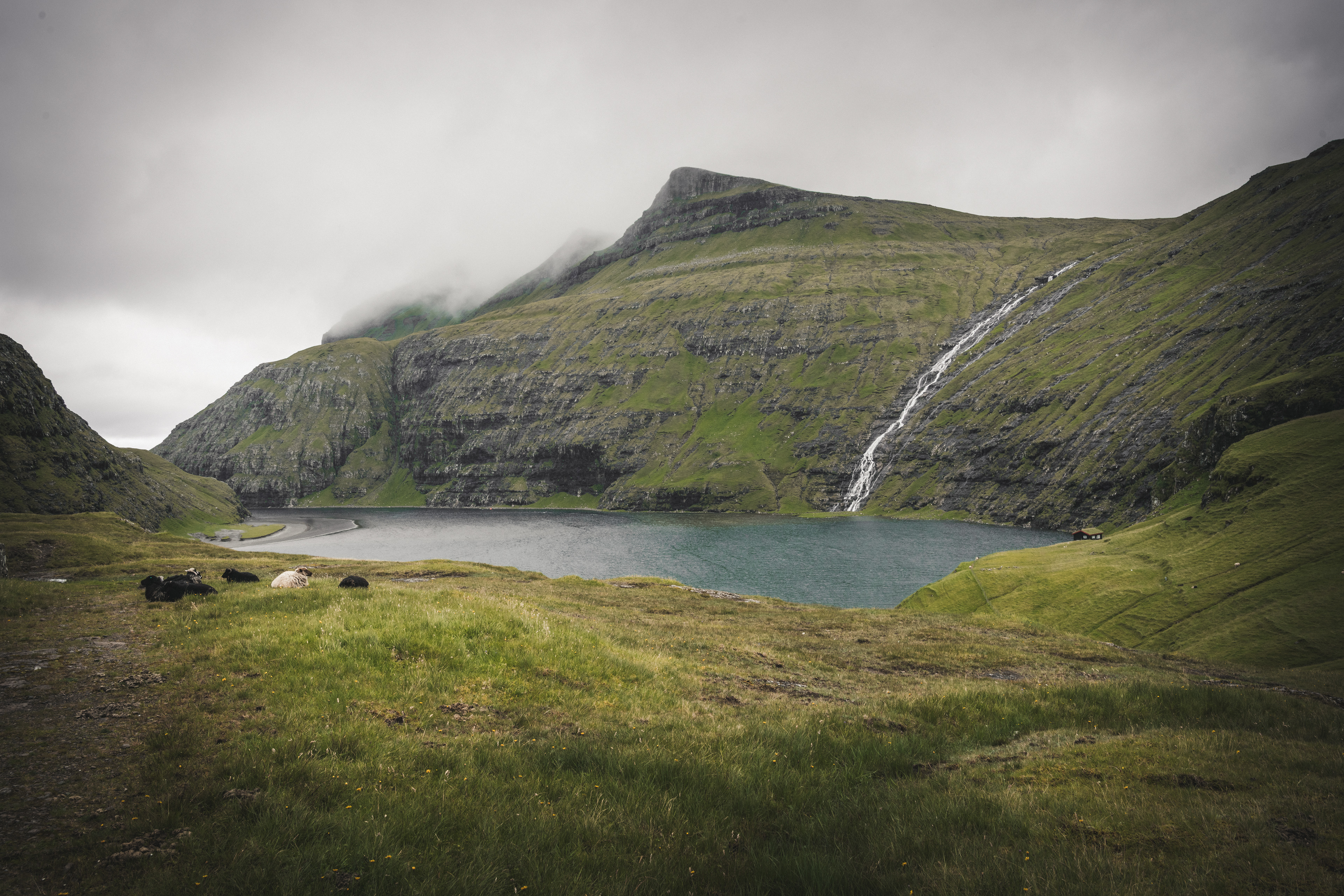 The lake holds the cliffs in silence. Water arrives and leaves without interruption.