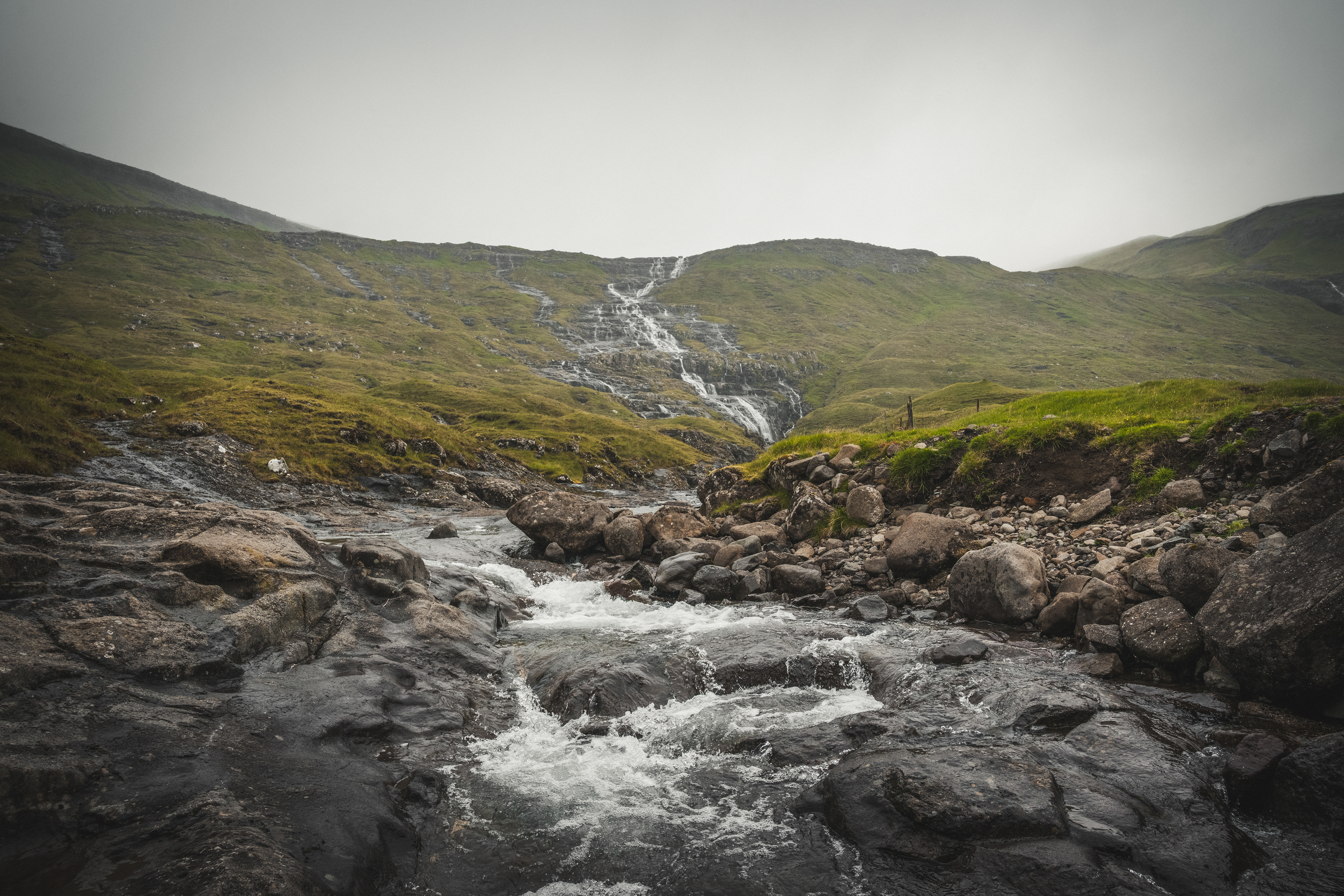 Water moves continuously across the land, shaping passage rather than destination. The valley absorbs the sound and carries it onward.