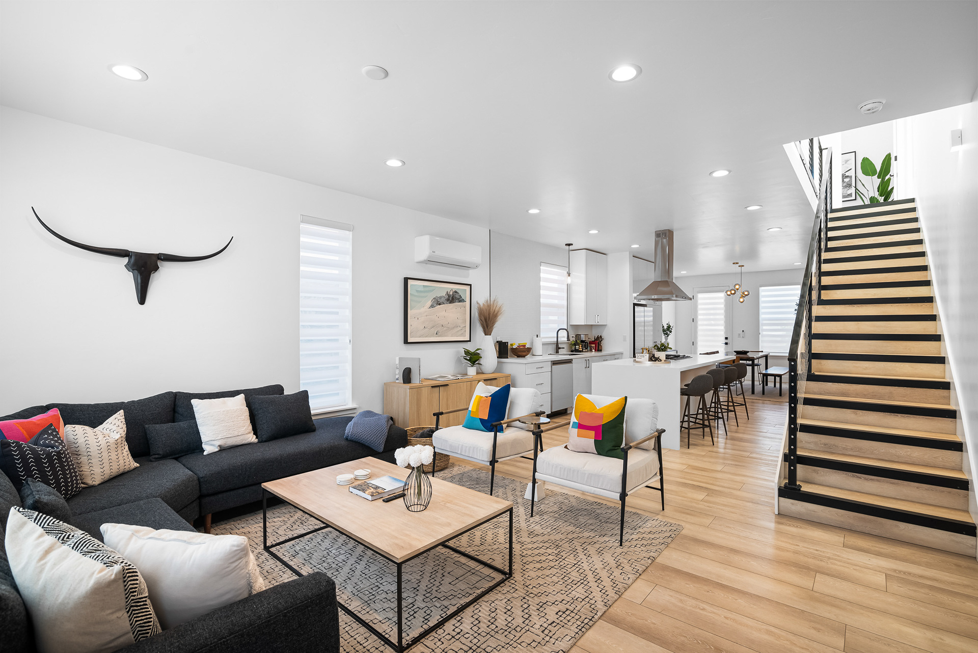 Interior real estate photography showing open-concept flow from entrance to living room, kitchen, and staircase in Temecula city home - Andrew Crippen Visuals