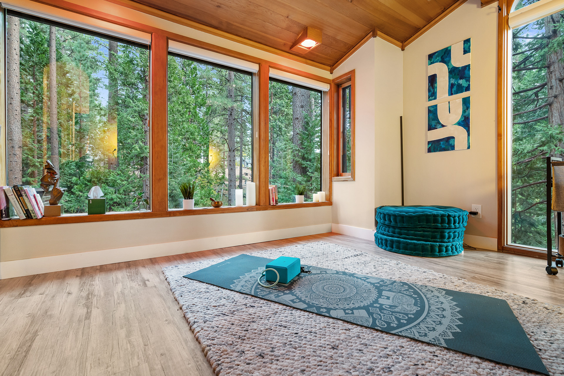 Interior photography of serene yoga room with floor-to-ceiling windows and forest views for vacation rental listing - Andrew Crippen Visuals