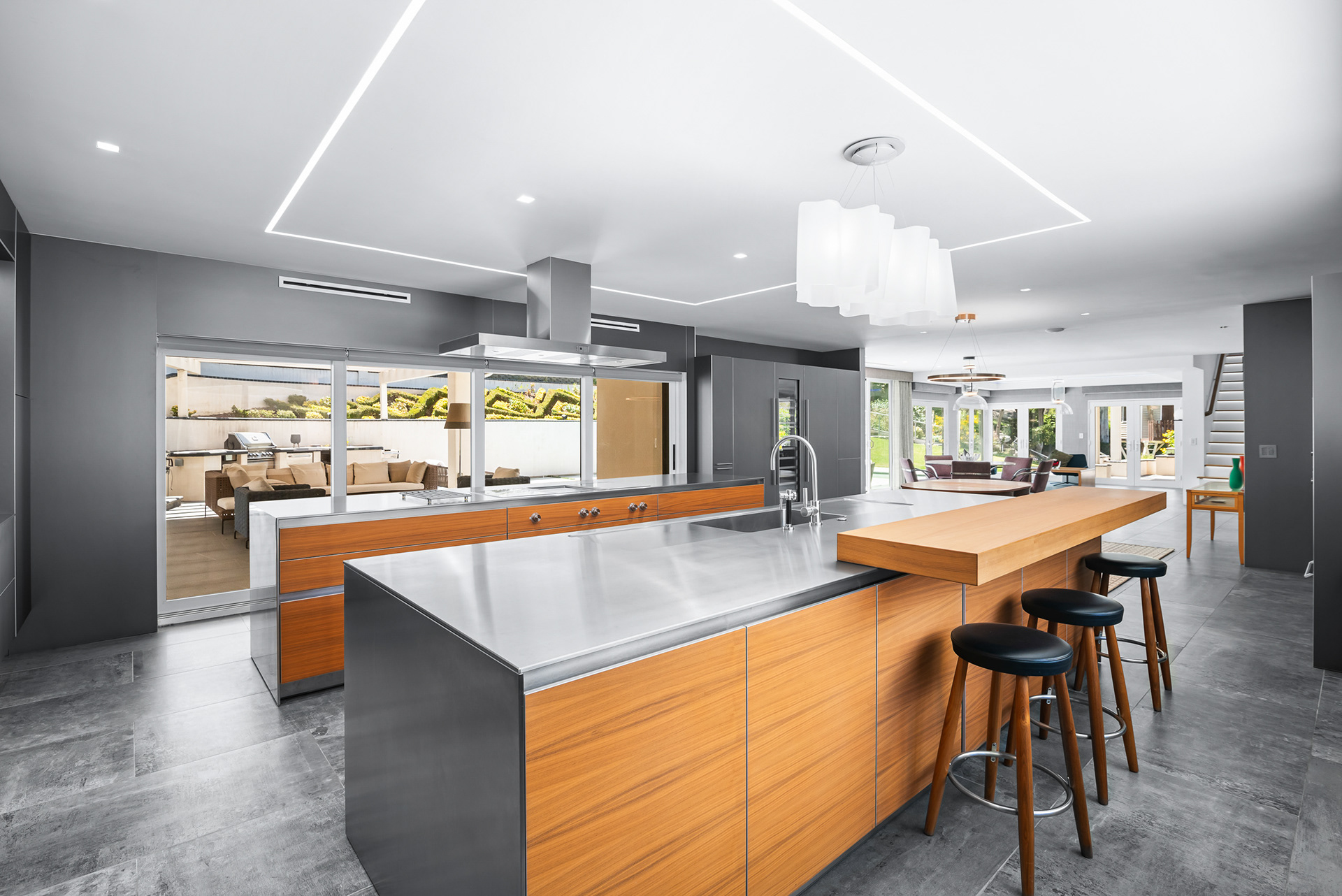 Architectural photography of sleek stainless steel breakfast bar with modern stools in La Cresta luxury estate listing