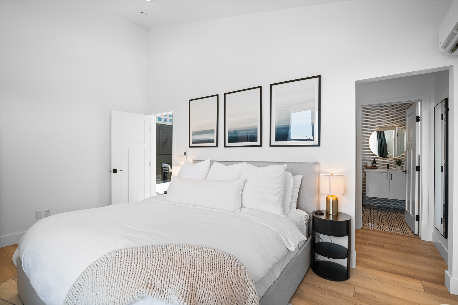 Interior real estate photography of modern master bedroom looking out towards the private bathroom in Temecula city home - Andrew Crippen Visuals