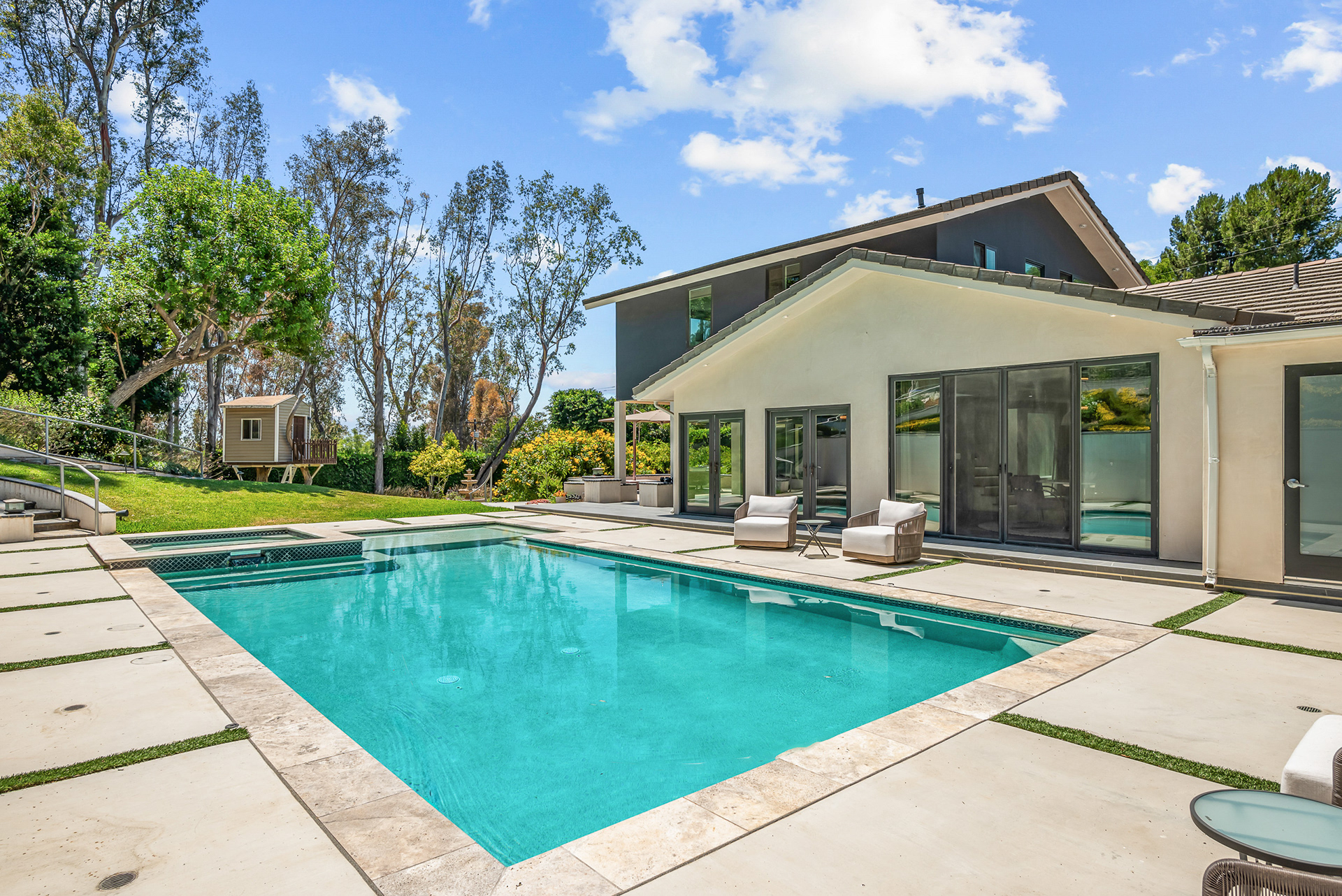 Secluded backyard oasis photography featuring lush private landscaping surrounding a modern pool and outdoor kitchen area in La Cresta estate - Andrew Crippen Visuals