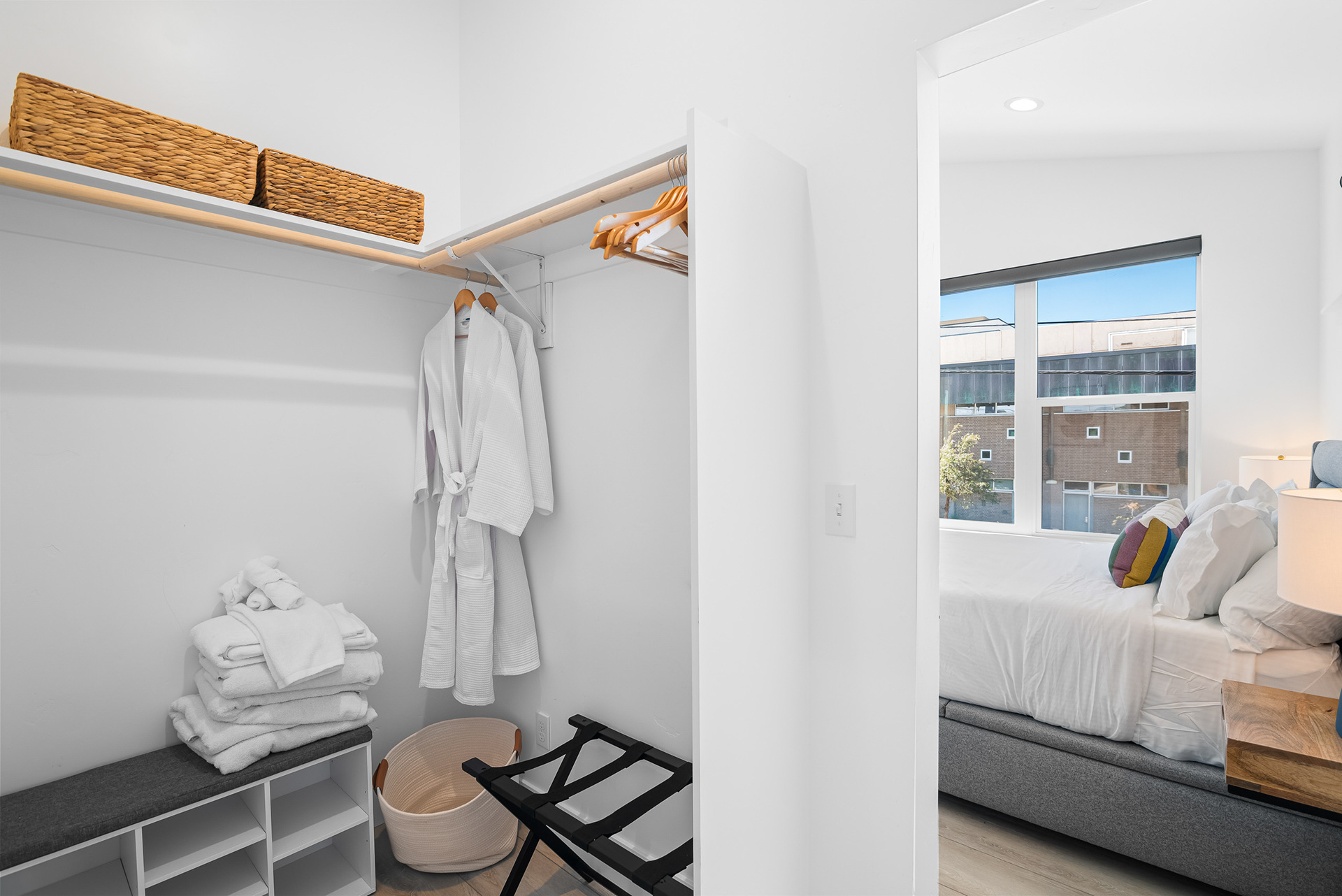 Interior real estate photography of walk-through master closet connecting bedroom and bathroom with custom built-in bench in Temecula - Andrew Crippen Visuals