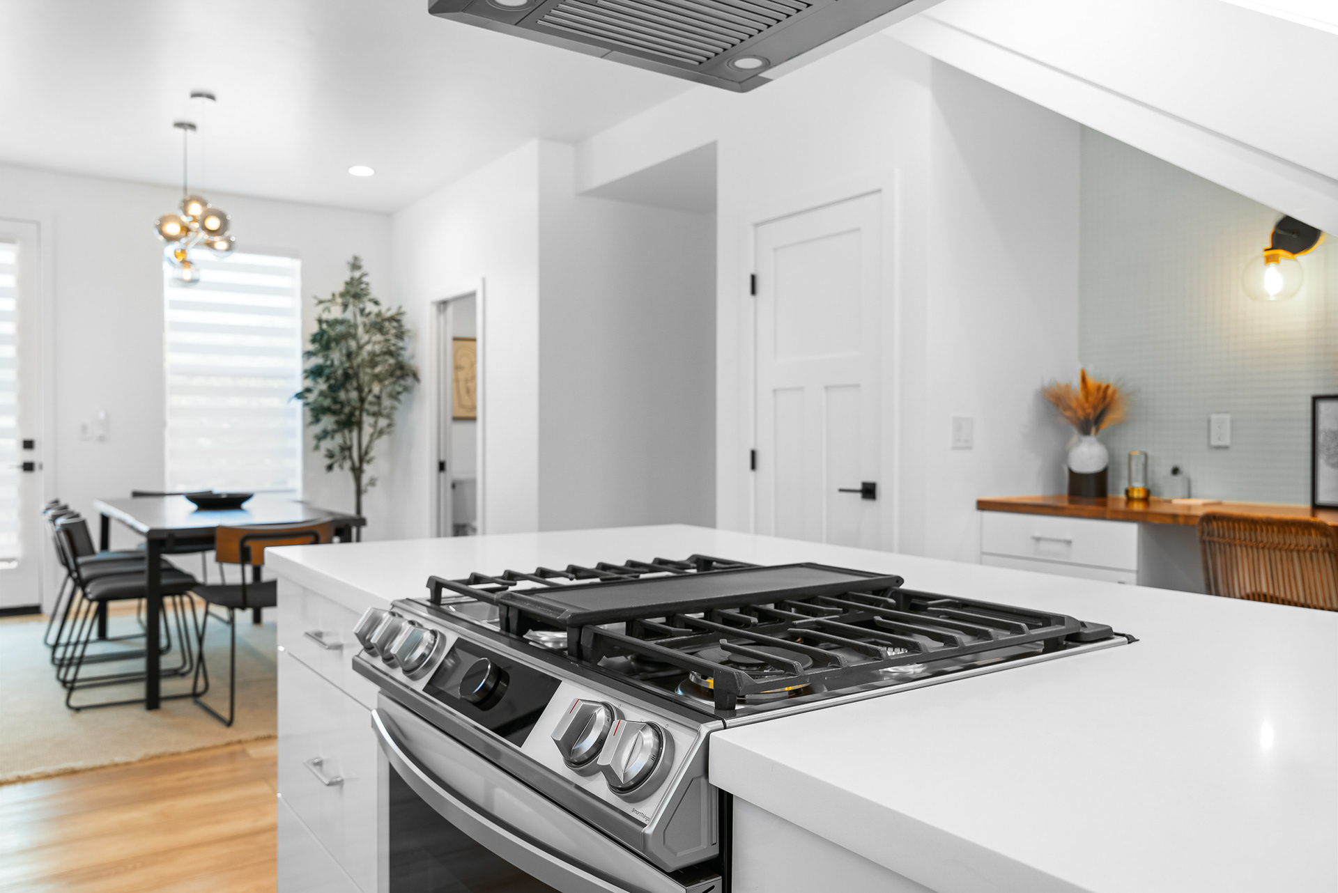 Close-up interior shot of modern oven and stovetop integrated into kitchen island design in Wildomar city home listing