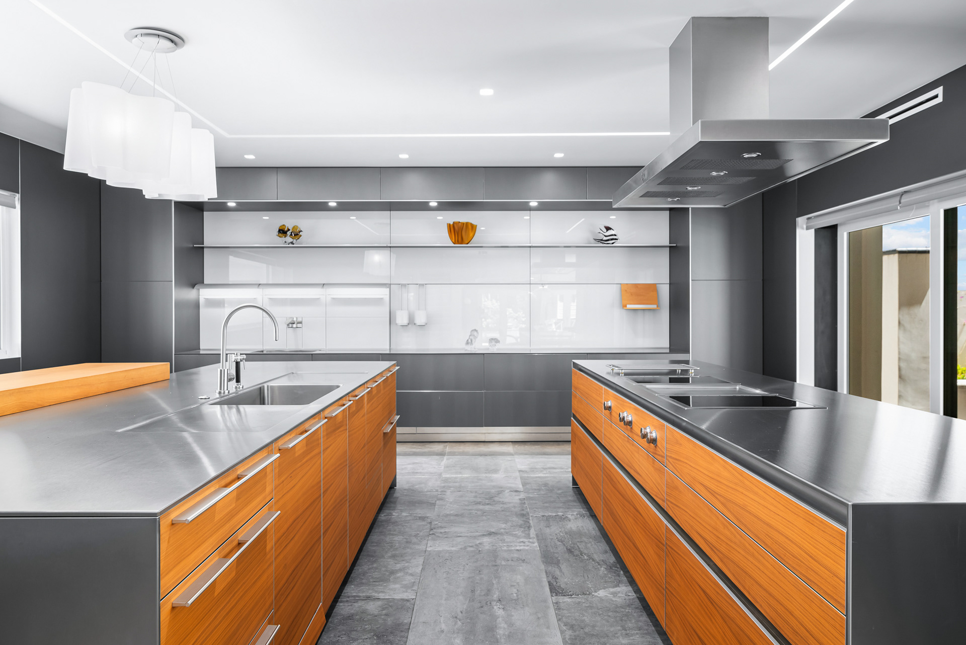 Close-up architectural shot of custom stainless steel kitchen surfaces and built-in cooktop in Temecula modern estate