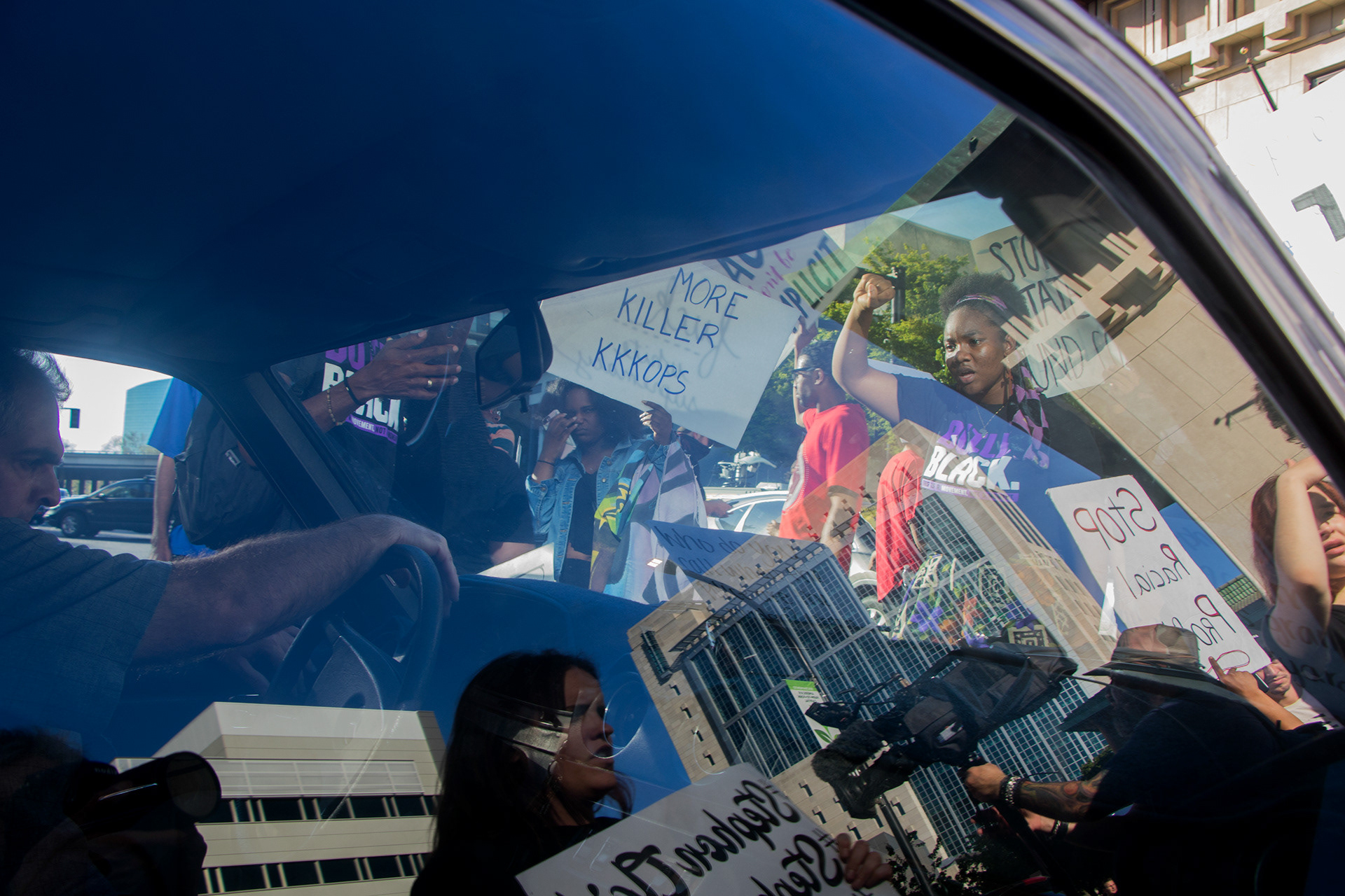 Demonstrators surround a man's vehicle after he attempts to drive around the crowd that was blocking the streets during a Stephon Clark protest in downtown Sacramento, Calif. on March 28, 2018.