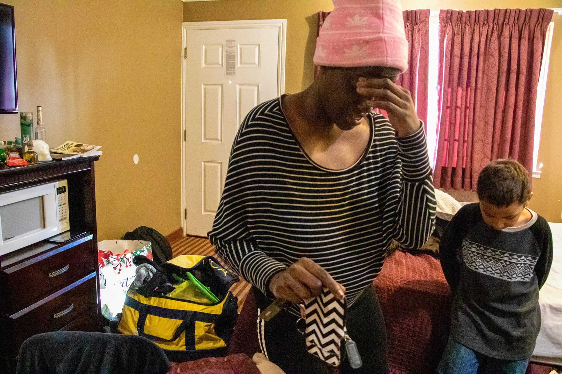 Duren-Hill places her hand over her forehead as she scrambles up change from her wallet to pay for another night at the Americas Best Value Inn on 16th Street in downtown Sacramento, Calif. on Jan. 3, 2019.
