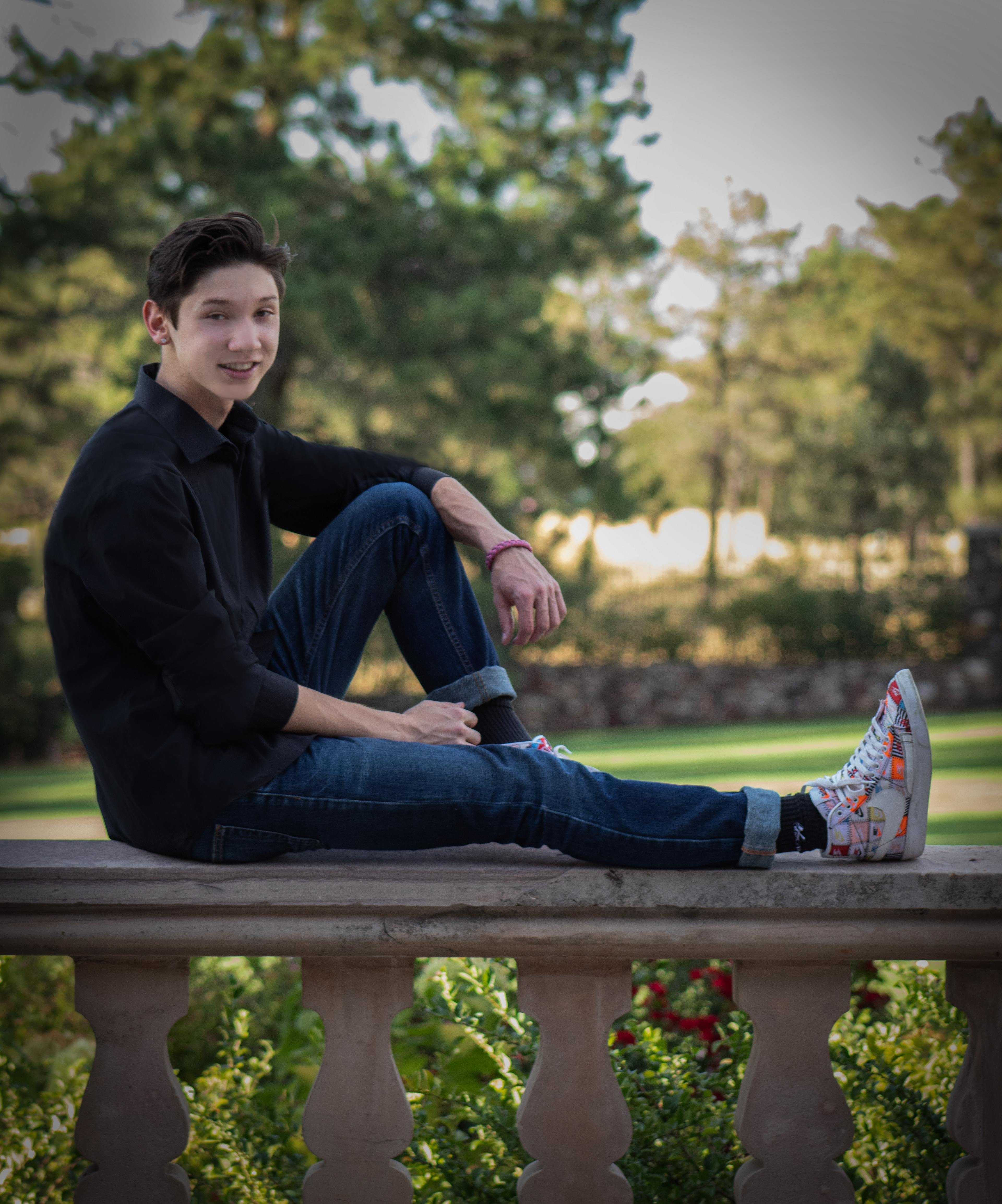 High school senior boy sitting on a railing outdoors