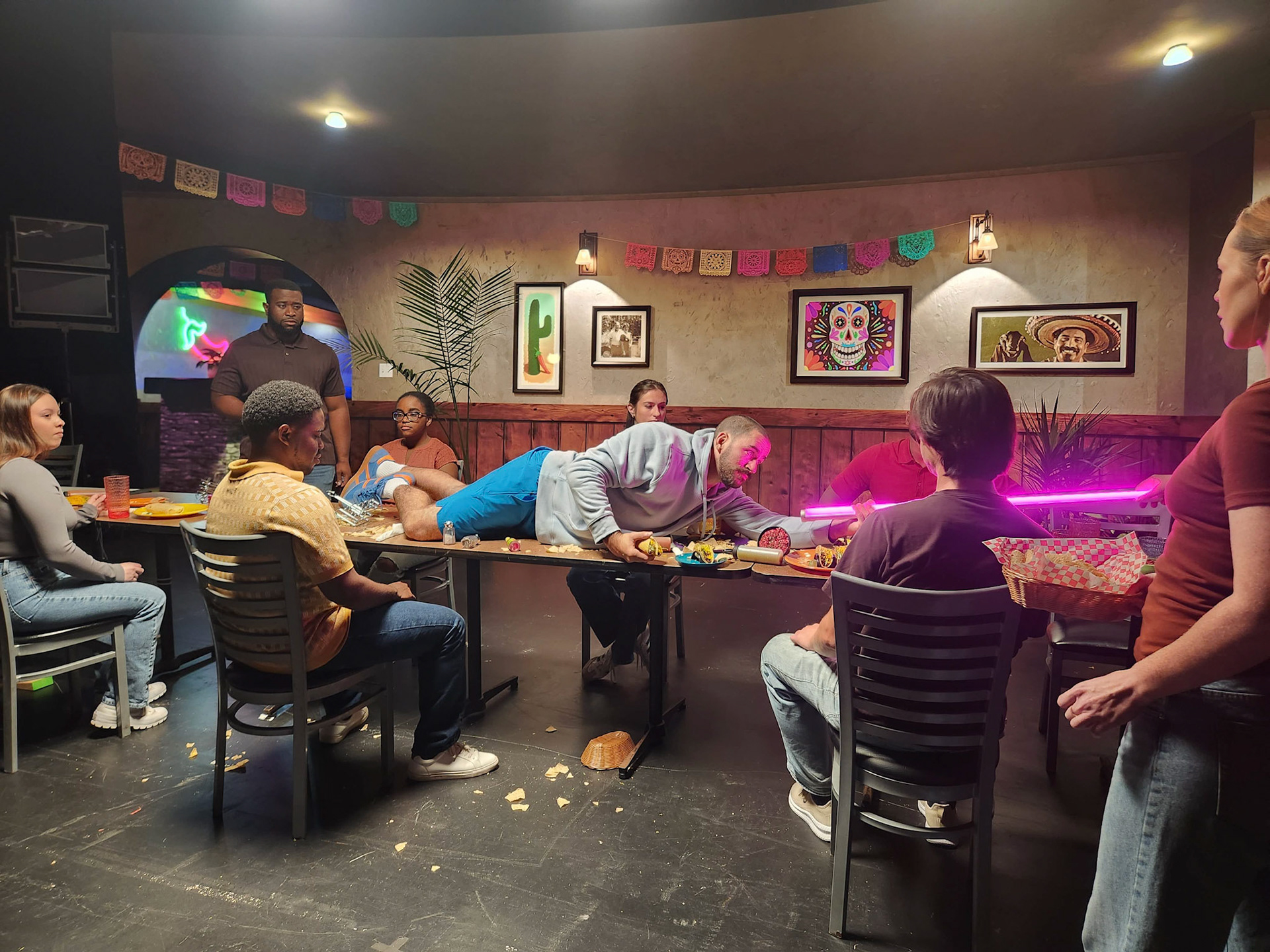 Stunt actor being pulled through table props.