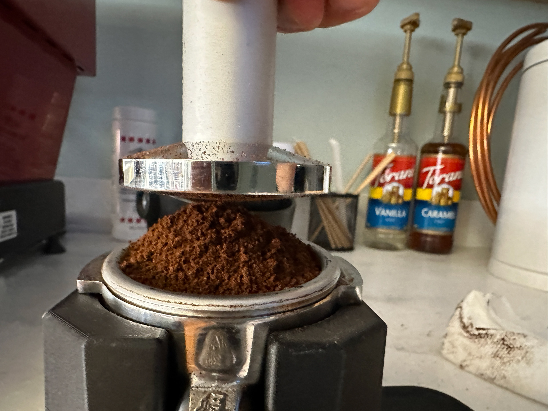 Attempting to tamp a pile of grounds? Maybe we should tap and level it first. But tapping to level it will often spill grounds too!
