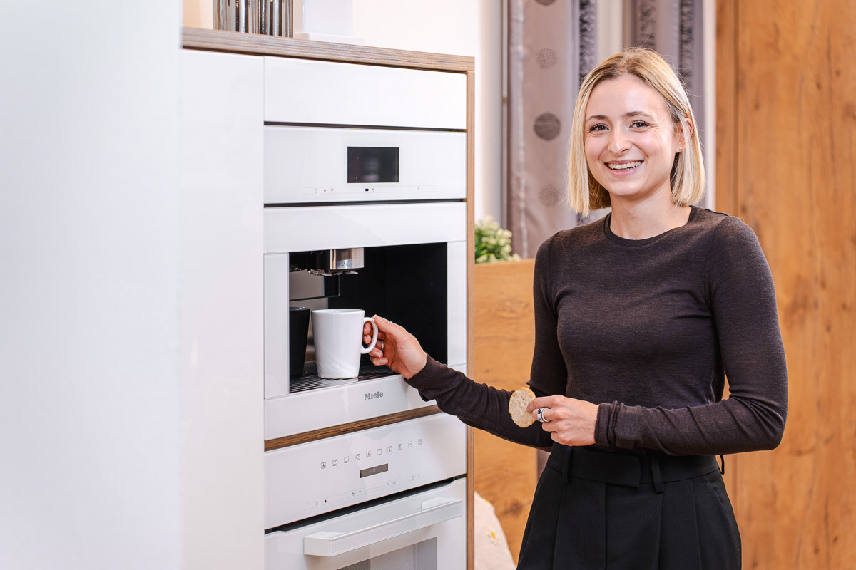 Showroom von Birkl-Inntalkuechen, Frau testet Kaffeemaschine,